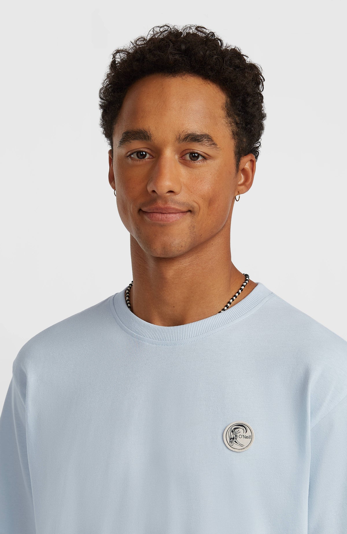 O'Riginals Badge T-Shirt für Herren, blau, Nahaufnahme am Model mit rundem Logo-Badge