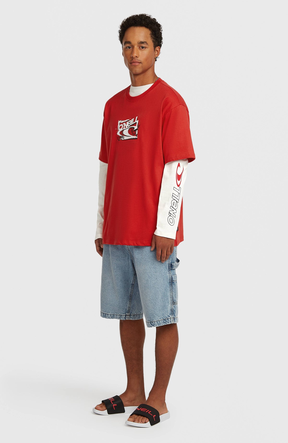 Essentials 90s Logo T-Shirt für Herren, rot mit Logo-Print, getragen am Model in Ganzkörperansicht