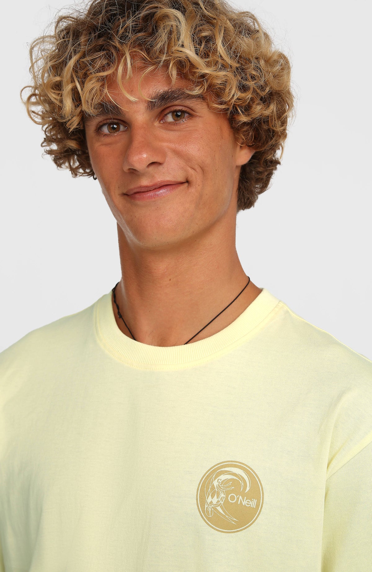 Nahaufnahme von Rundhalsausschnitt und Brust-Print des gelben O'Riginals Surf Shop T-Shirts am Model