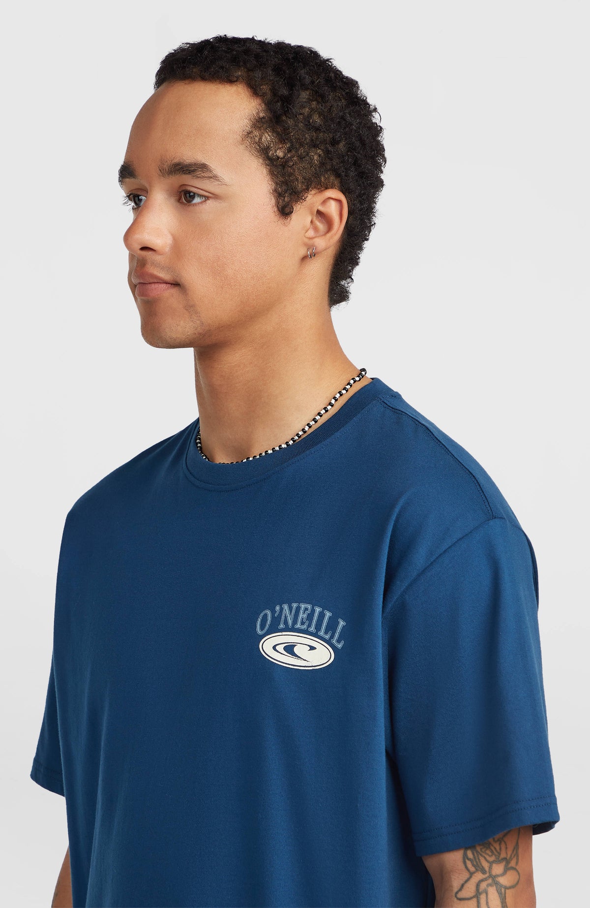 Nahaufnahme des Muir Chest Print T-Shirts für Herren in Blau mit Rundhalsausschnitt und Logo-Print am Model