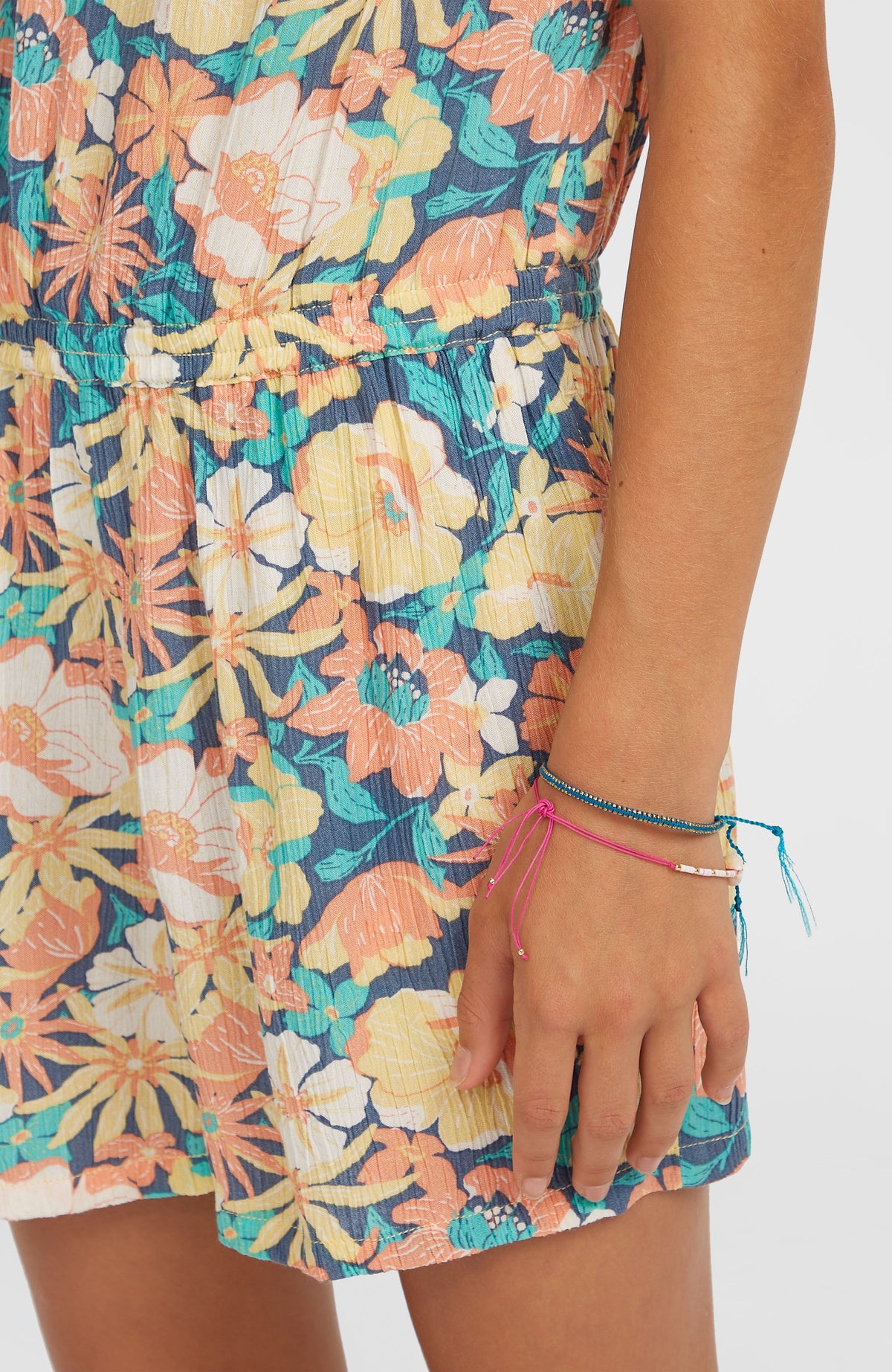 Gewebter Sommer-Playsuit für Mädchen, blau mit Blumenmuster in Gelb und Orange, Nahaufnahme von Taillenbund und Hosensaum
