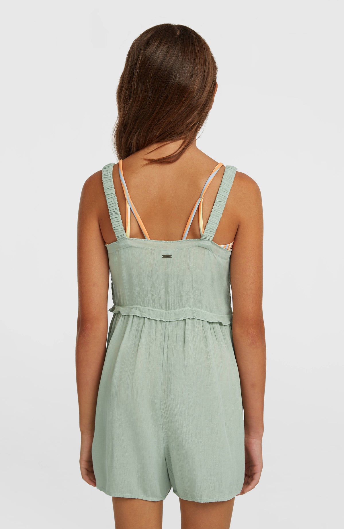 Grüner Woven Playsuit für Mädchen, Rückansicht am Model mit geradem Abschluss und Rüschenbund