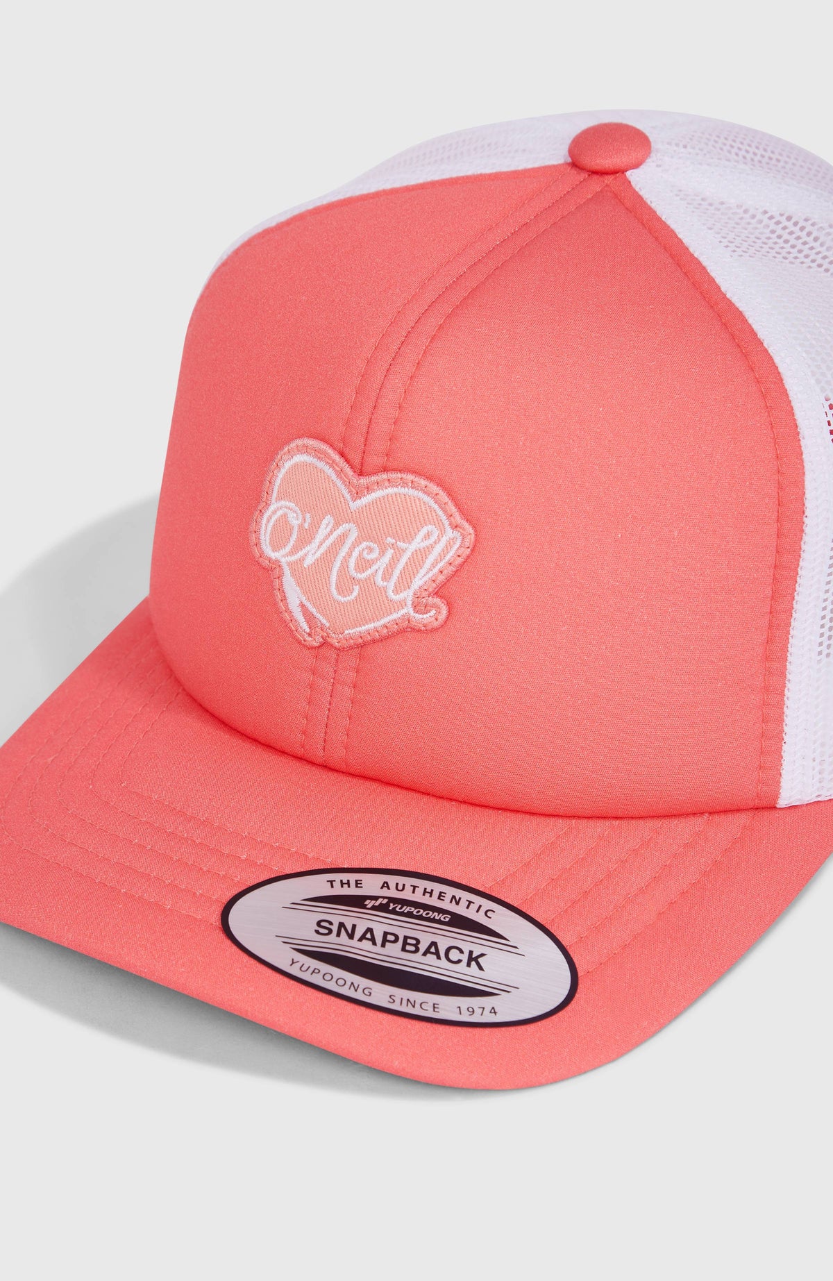 Nahaufnahme des herzförmigen Logo-Badges auf der pinken Flood Trucker Cap