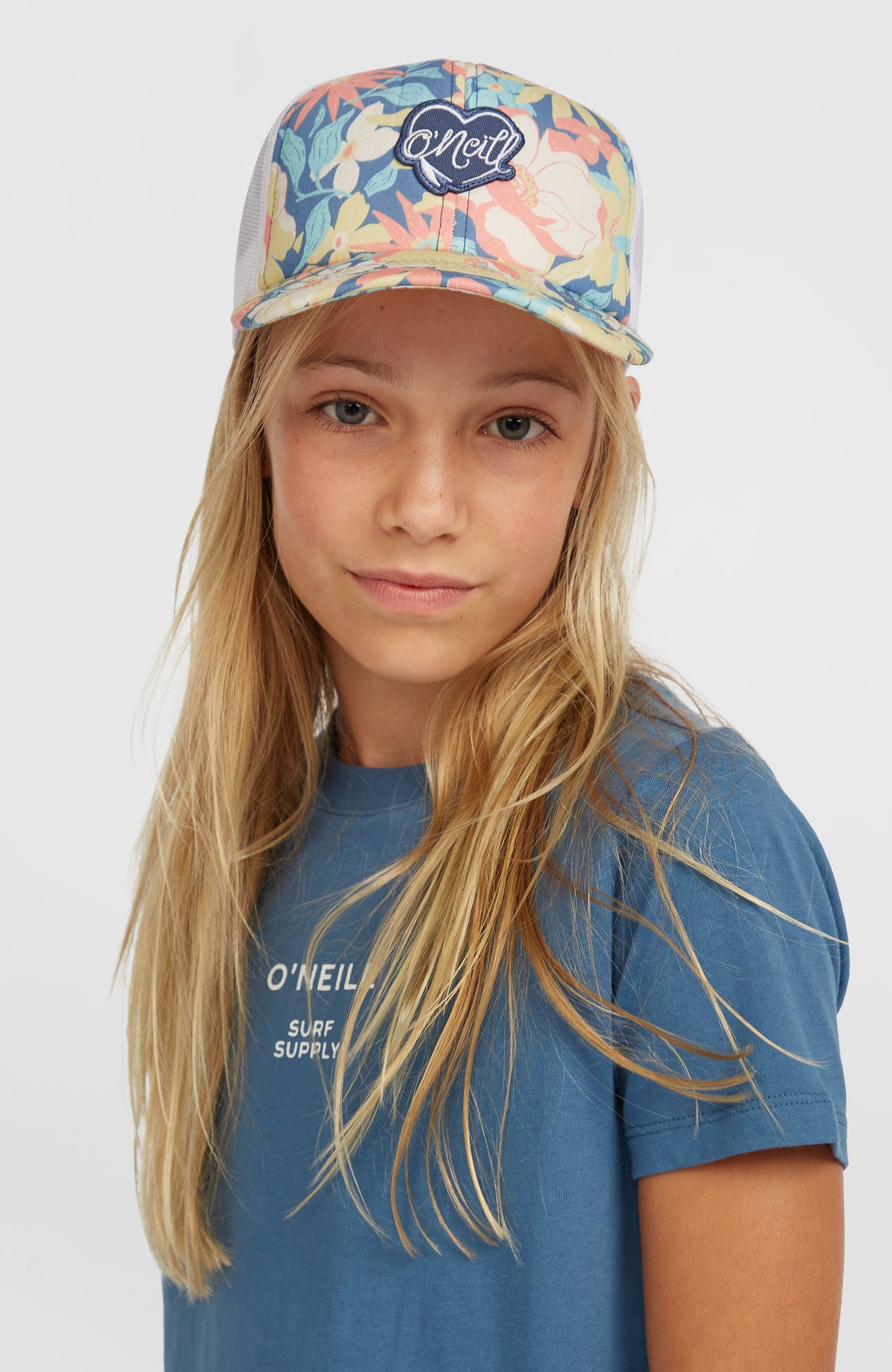 Flood Trucker Cap für Mädchen, blau mit Blumenmuster in Gelb und Rosa, getragen am Model, Frontalansicht