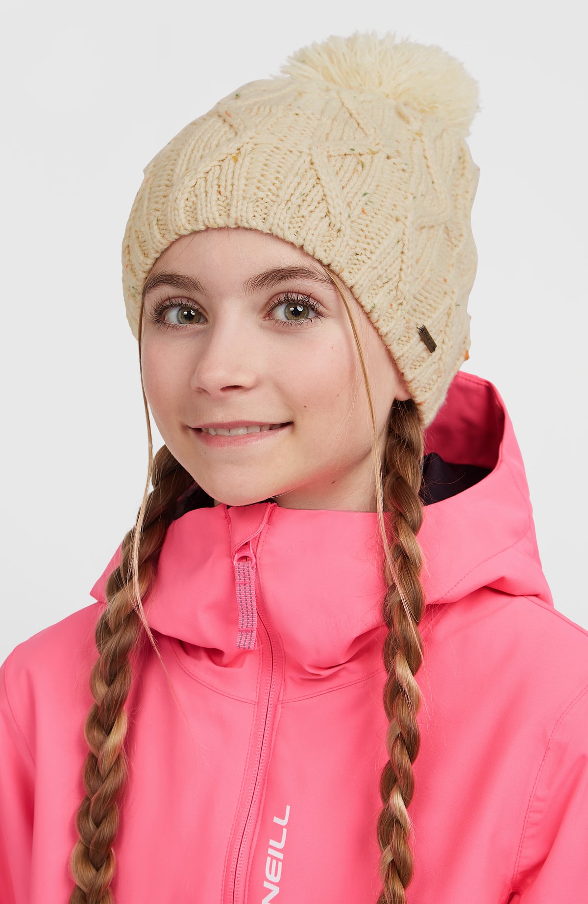 Nora Mütze für Mädchen, beige, getragen am Model, Strickmütze mit Bommel in der Vorderansicht