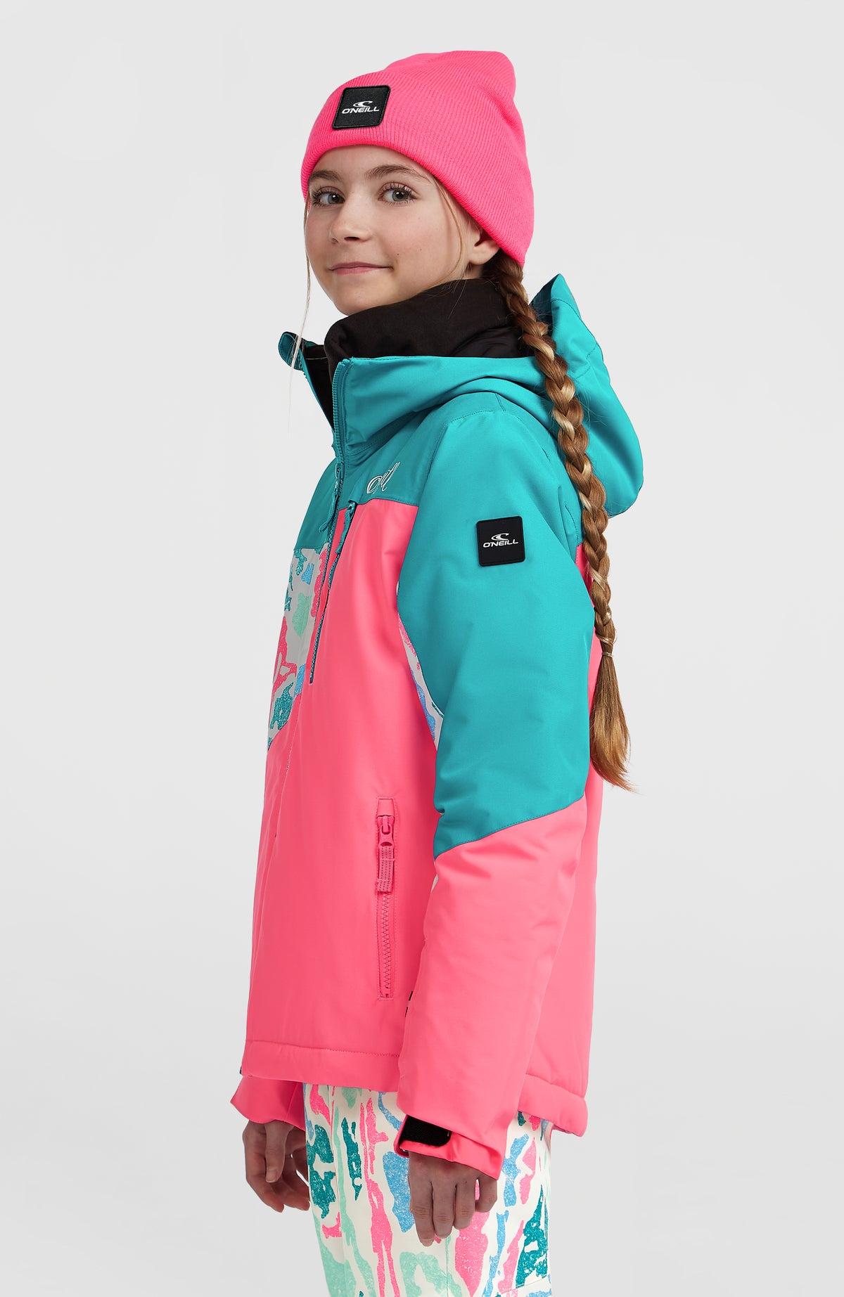 FWC'Cruz Triple Skijacke, weiß mit abstraktem Muster in Pink und Türkis, Seitenansicht am Model mit Logo-Badge am Ärmel