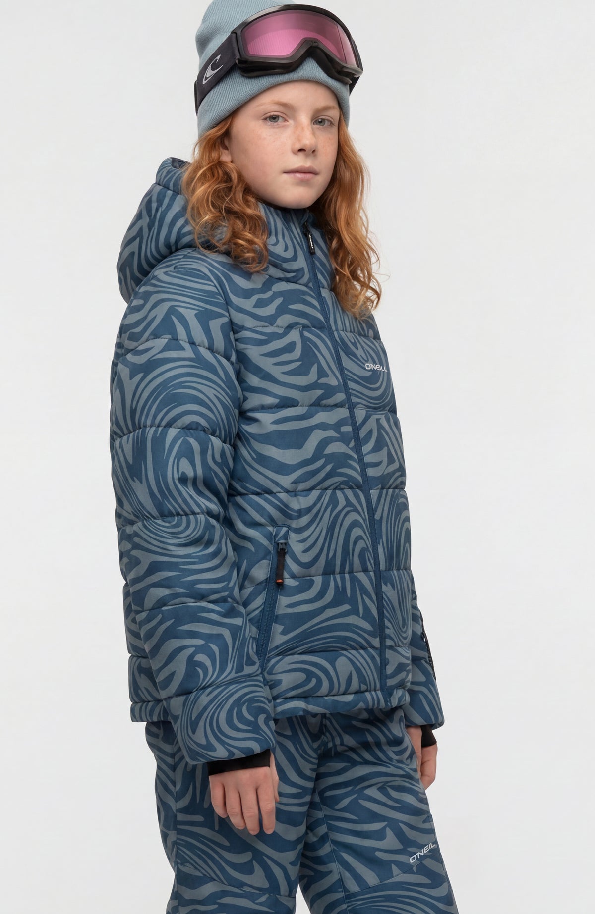 Gesteppte FWC'Cruz Skijacke für Mädchen, blau mit Wirbelmuster in Hellblau, Seitenansicht am Model, Seitentasche