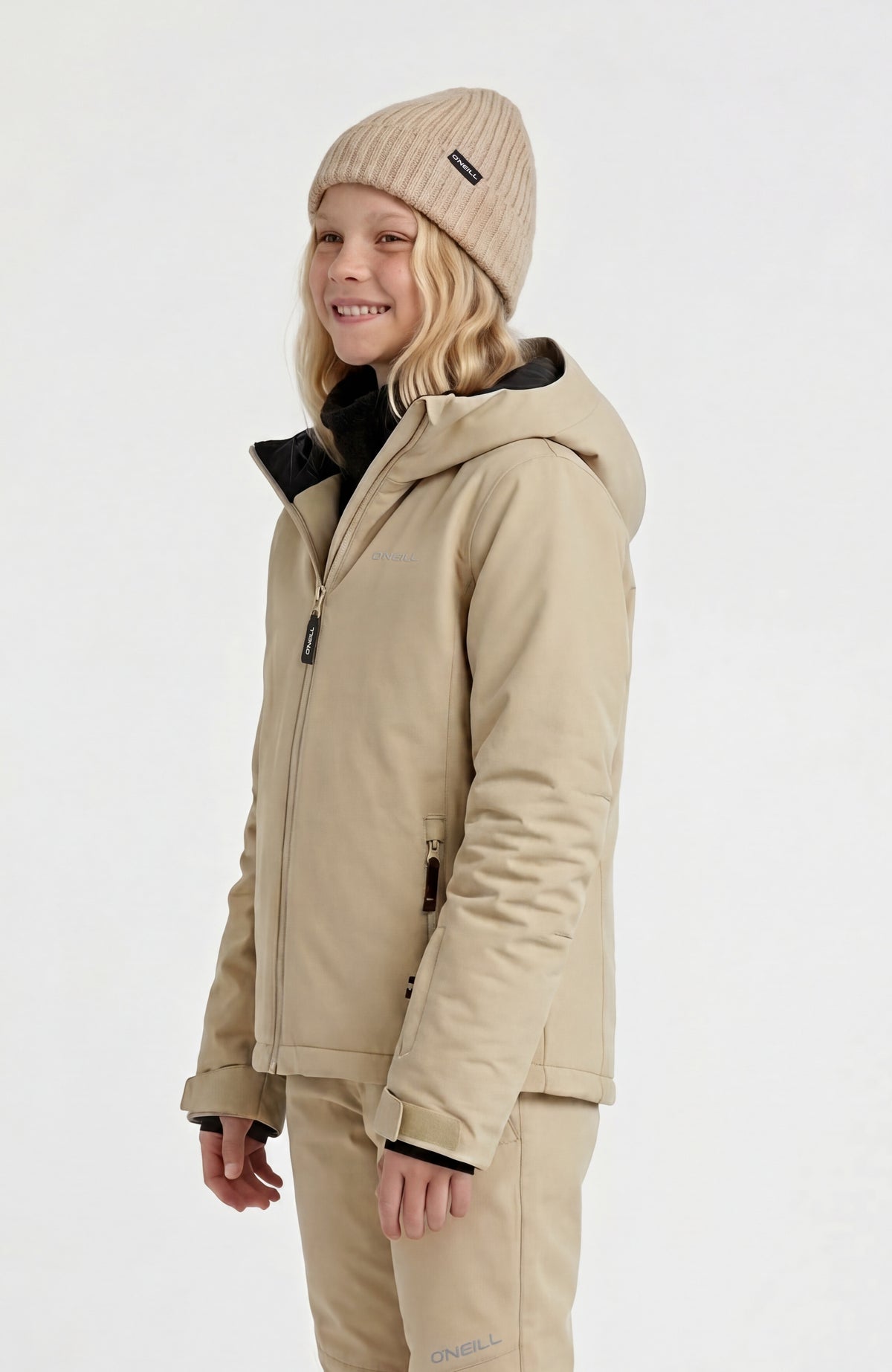 FWC'Cruz Skijacke für Mädchen, beige, Halbprofilansicht am Model, mit Kapuze und dezentem Logo auf der Brust