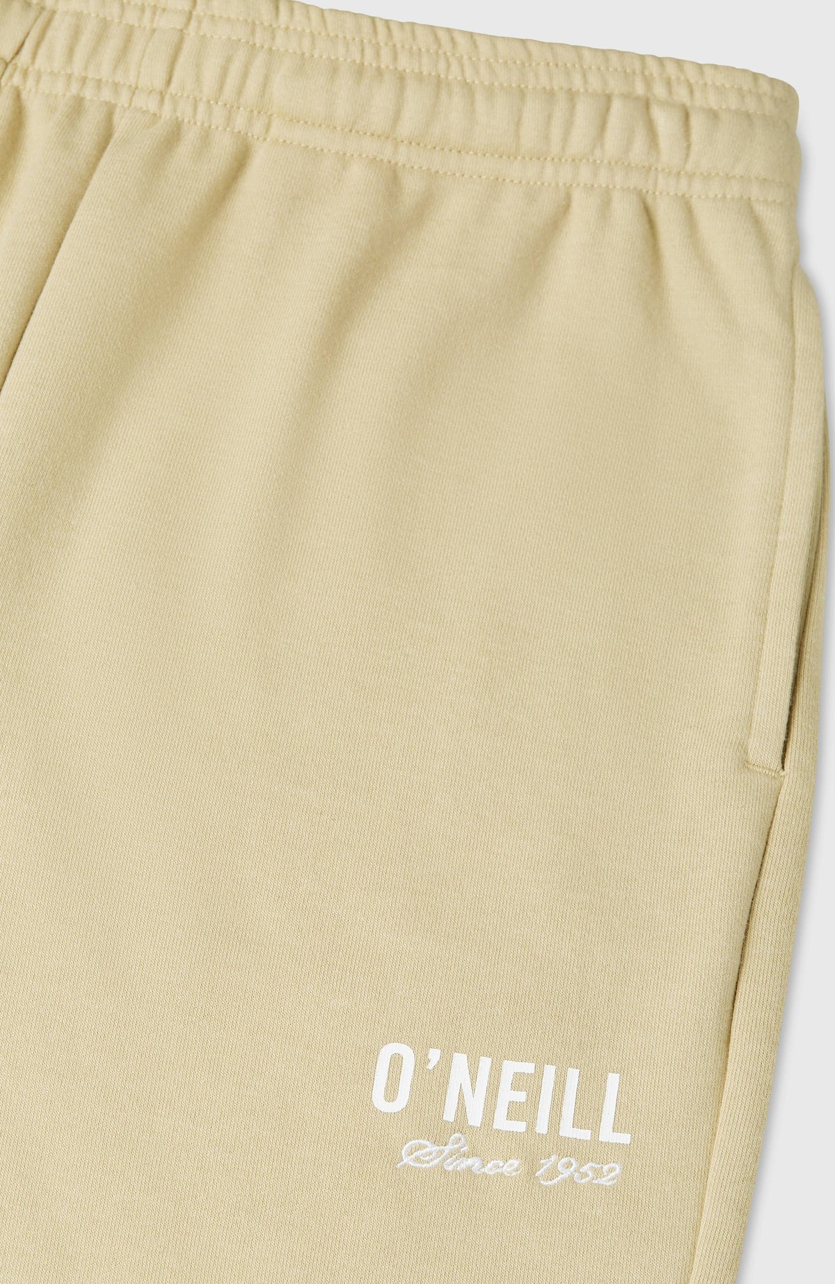 Beige Essentials Jogginghose, Nahaufnahme des weißen Logo-Schriftzugs und der Seitentasche