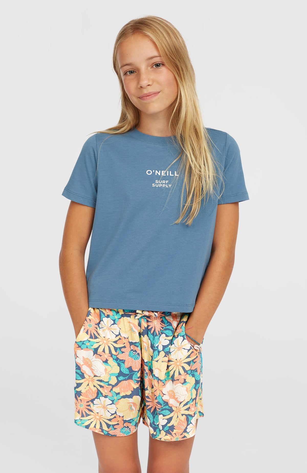 O'Neill Gewebte Sommershorts für Mädchen, blau mit Blumenmuster in Gelb und Orange, Vorderansicht am Model