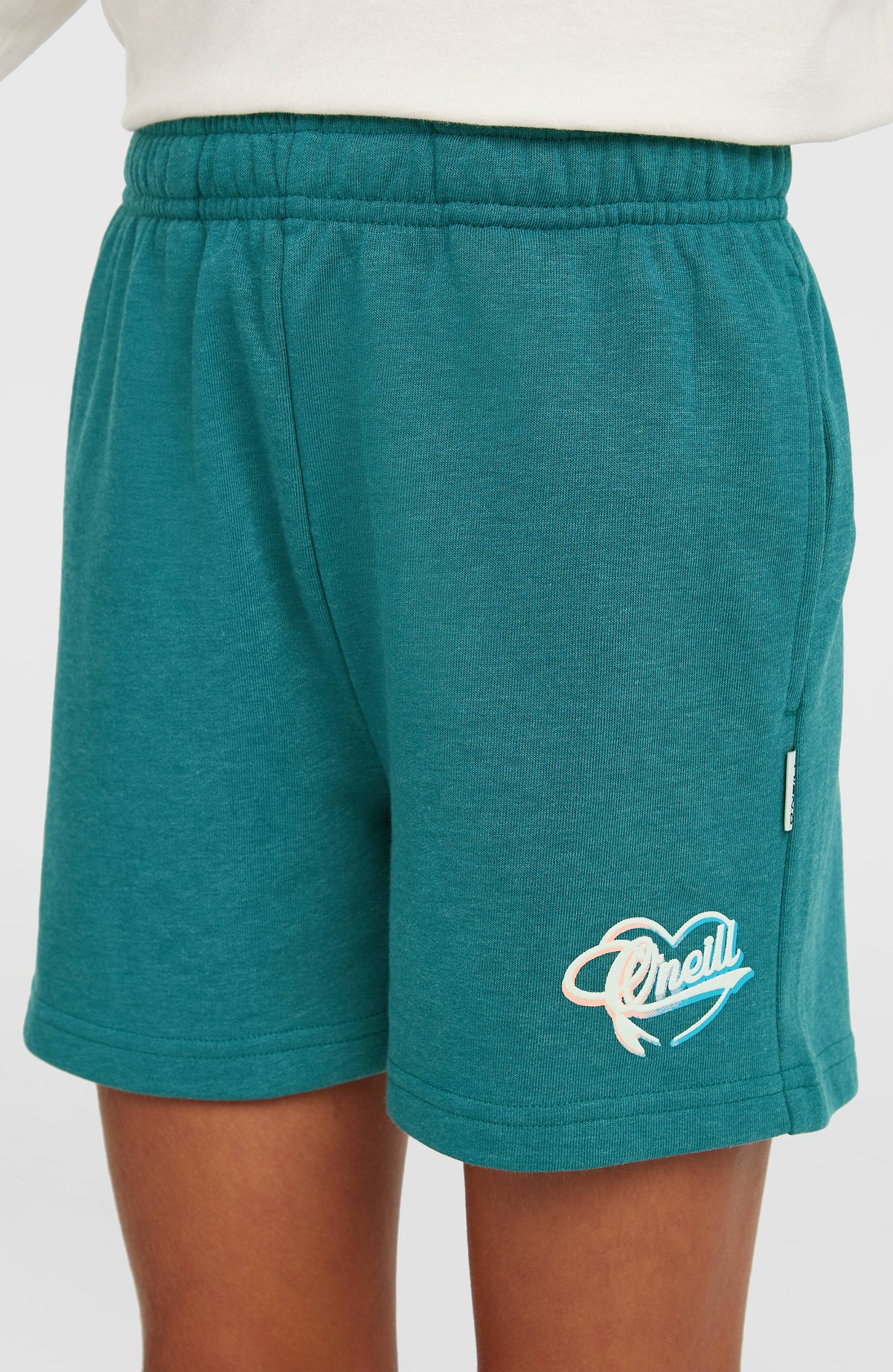 O'Neill Essentials Script Sweatshorts für Mädchen, grün, getragen am Model von vorne mit Logo-Print am Hosenbein