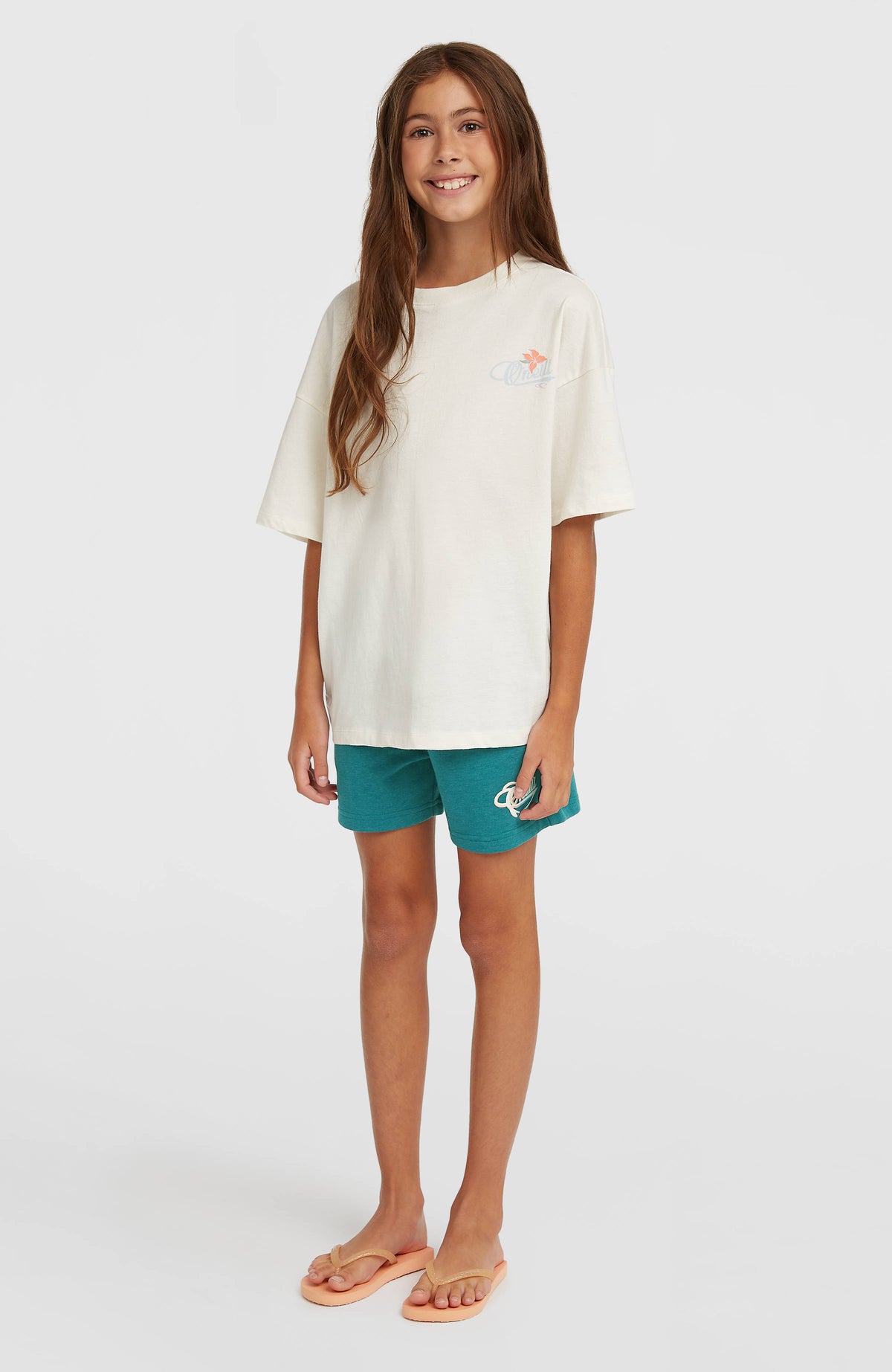 Essentials Script Sweatshorts für Mädchen, grün, getragen am Model in Ganzkörperansicht von vorne