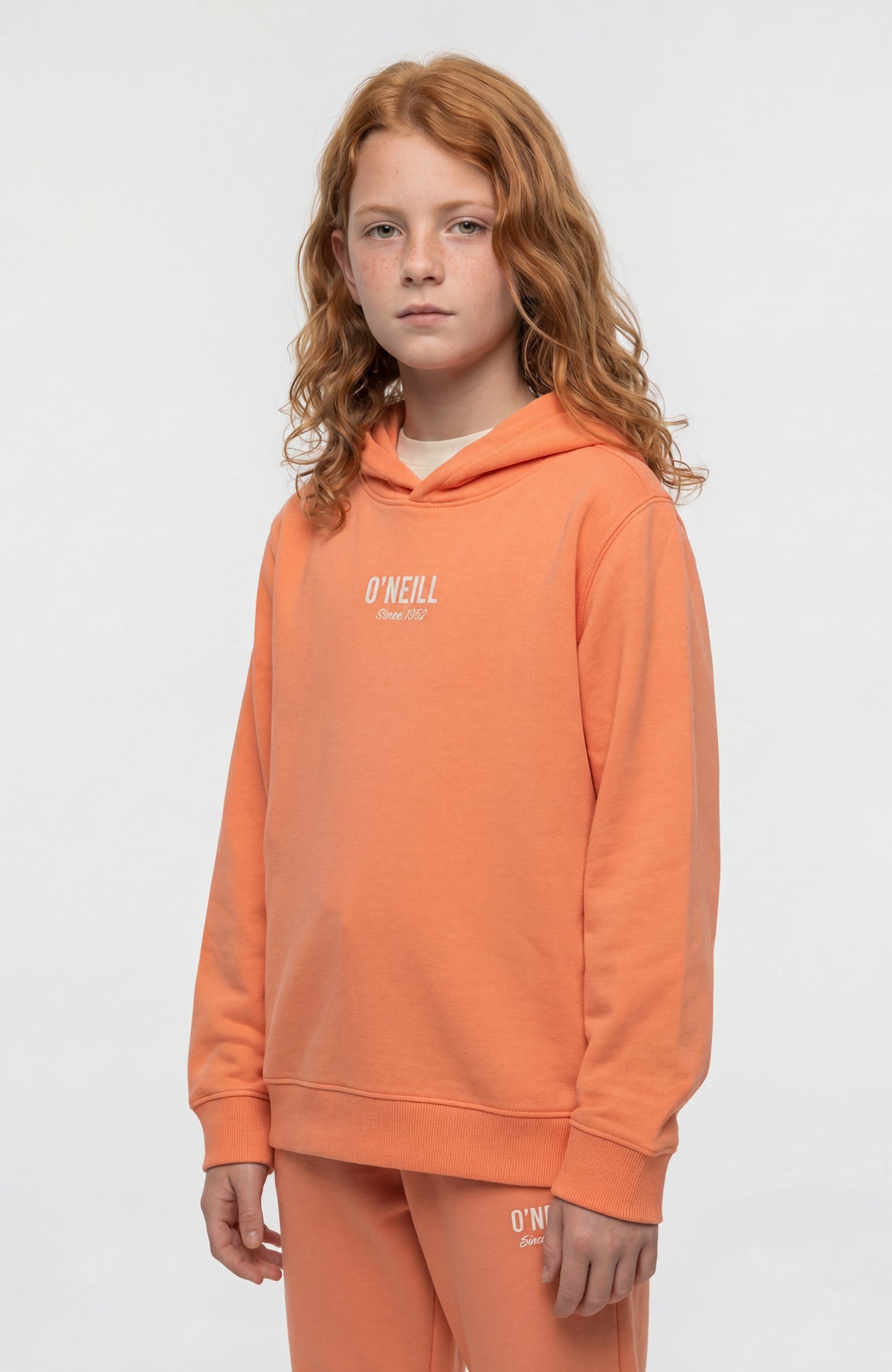 O'Neill Essentials Hoodie für Mädchen, orange mit Logo-Print in Weiß, Vorderansicht getragen am Model