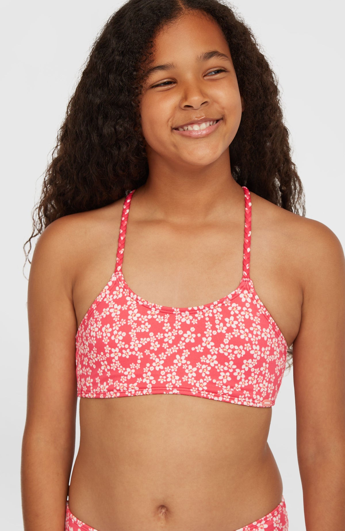 Tropics Bikini-Set für Mädchen, pink mit Blumenmuster in Weiß, Nahaufnahme des Bralette-Oberteils am Model