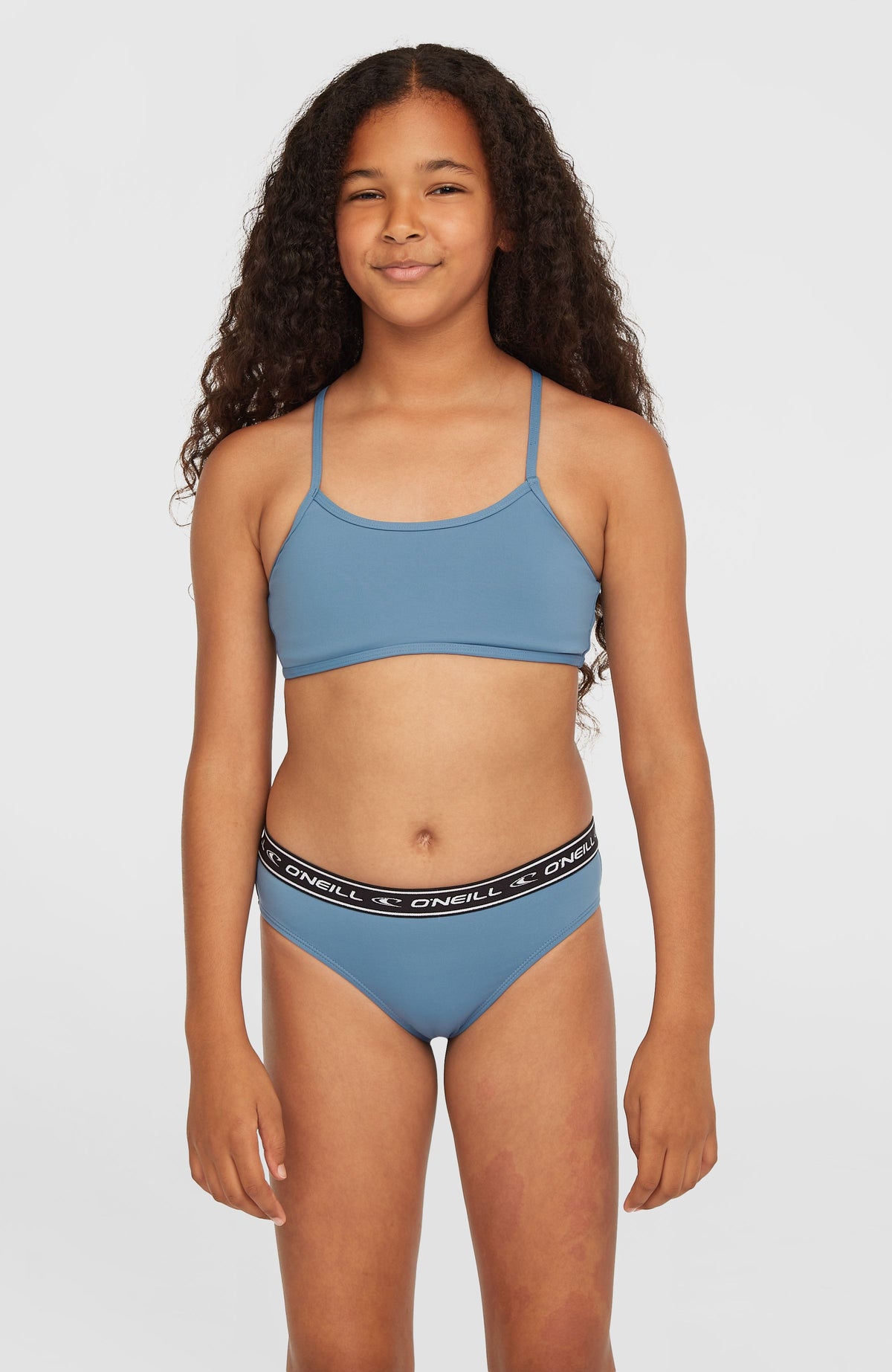 O'Neill Sportclub Bikini-Set für Mädchen, blau, Vorderansicht am Model mit elastischem Logo-Bund an der Hose