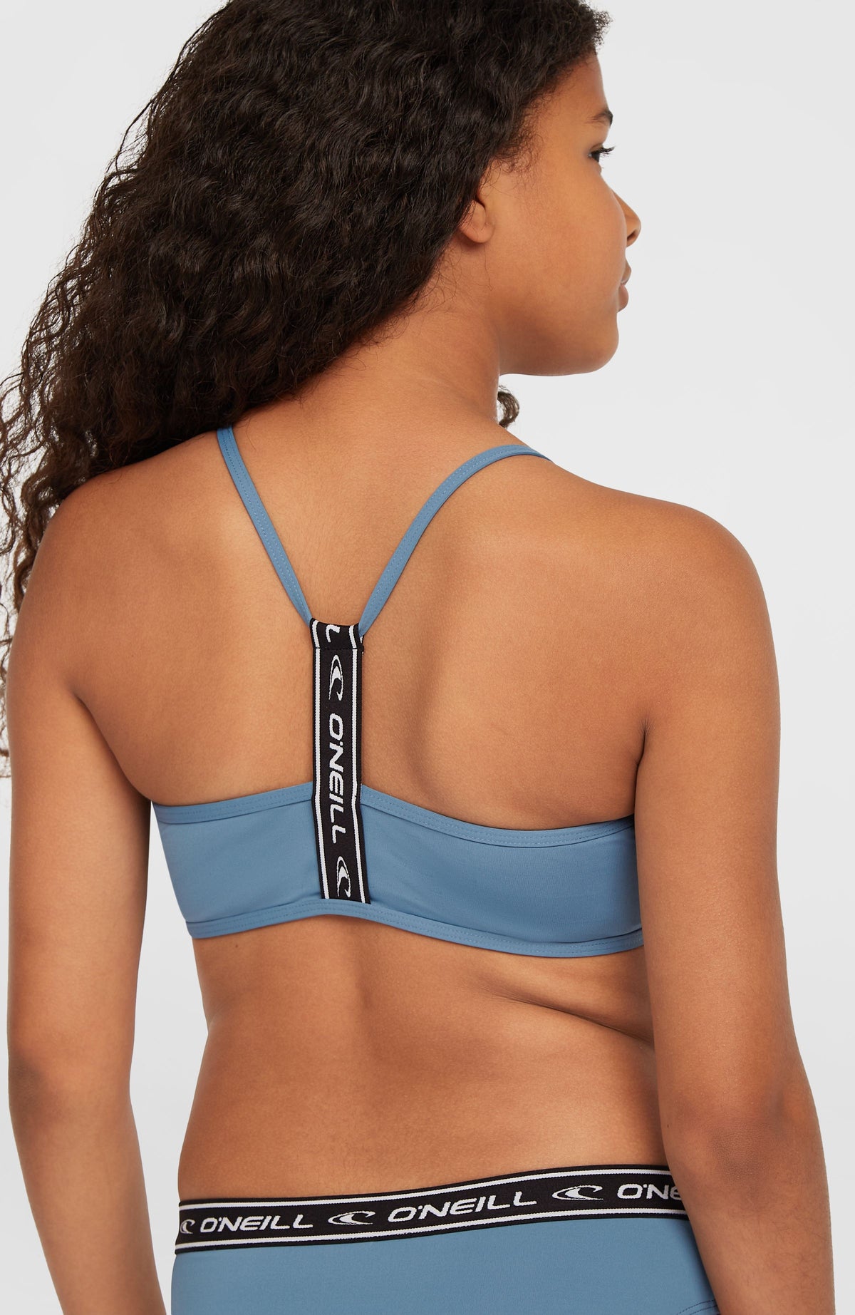 Sportclub Bikini-Set für Mädchen, blau, Nahaufnahme der Rückseite am Model mit elastischem Logo-Steg am Oberteil