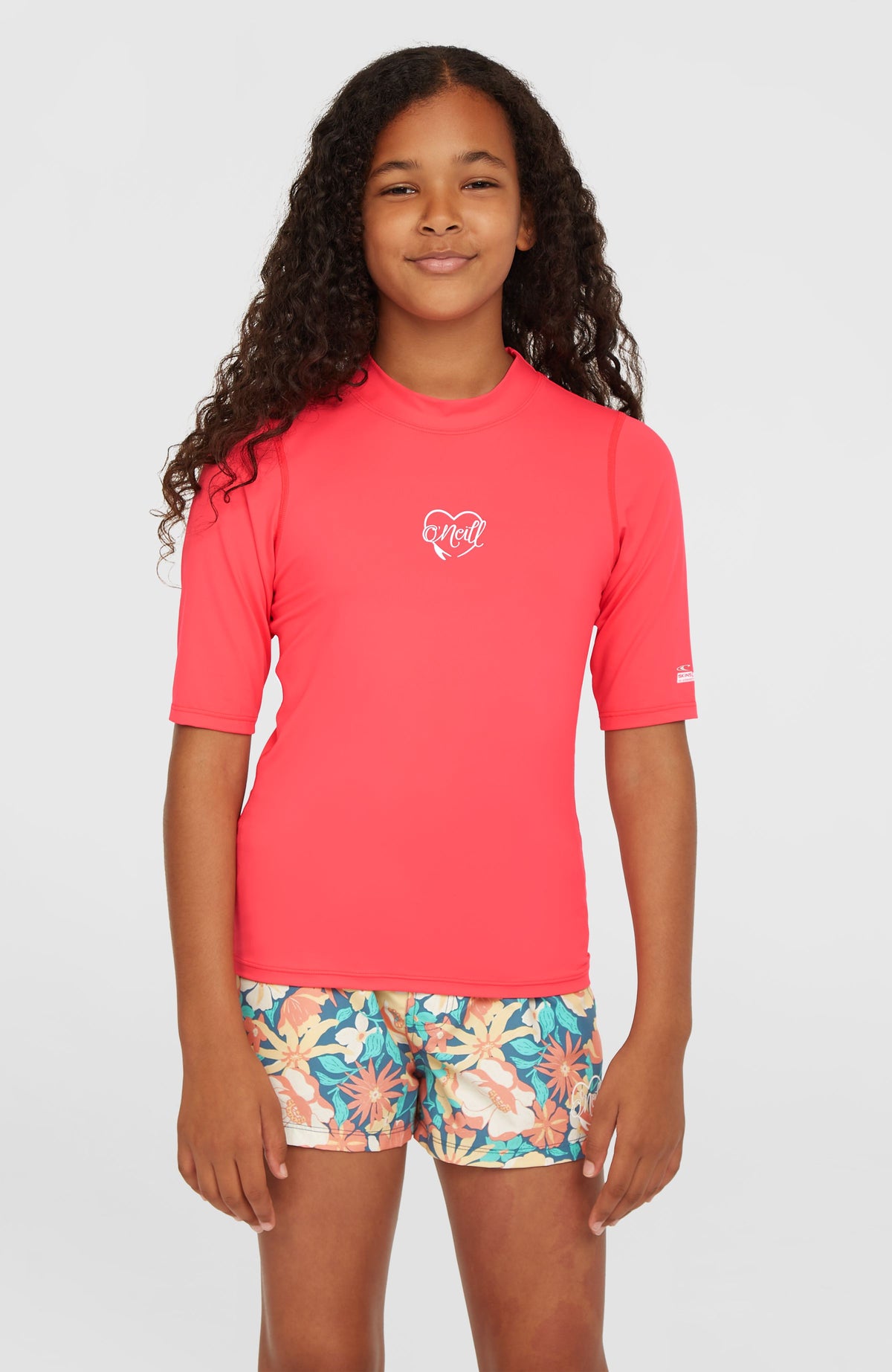 O'Neill Essentials Shortsleeve-Schwimmshirt für Mädchen, pink mit Logo-Print in Weiß, Vorderansicht am Model