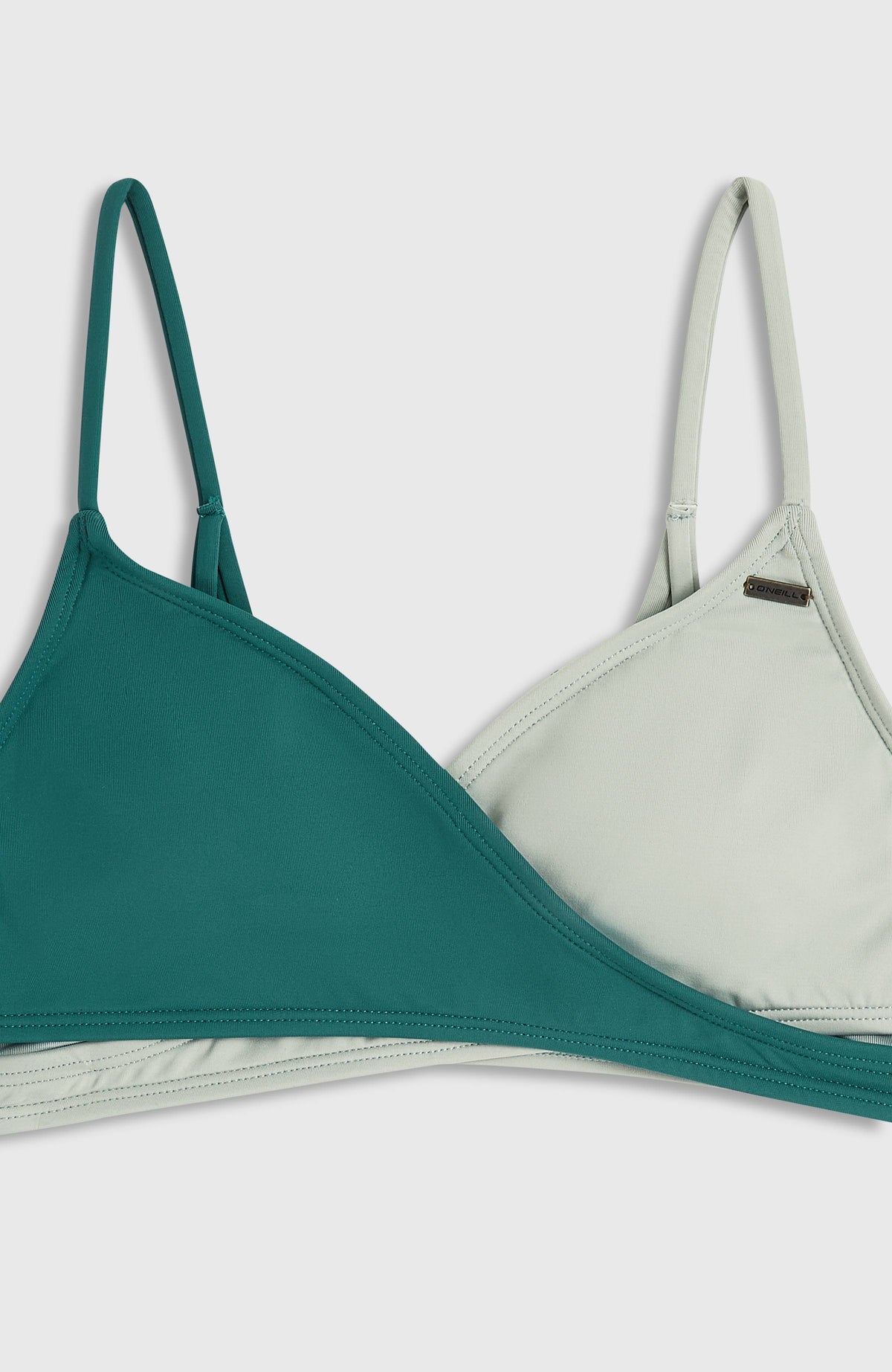 Nahaufnahme des zweifarbigen Bralette-Tops vom Essentials Baay Bikini-Set für Mädchen, grün, mit kleiner Logo-Plakette