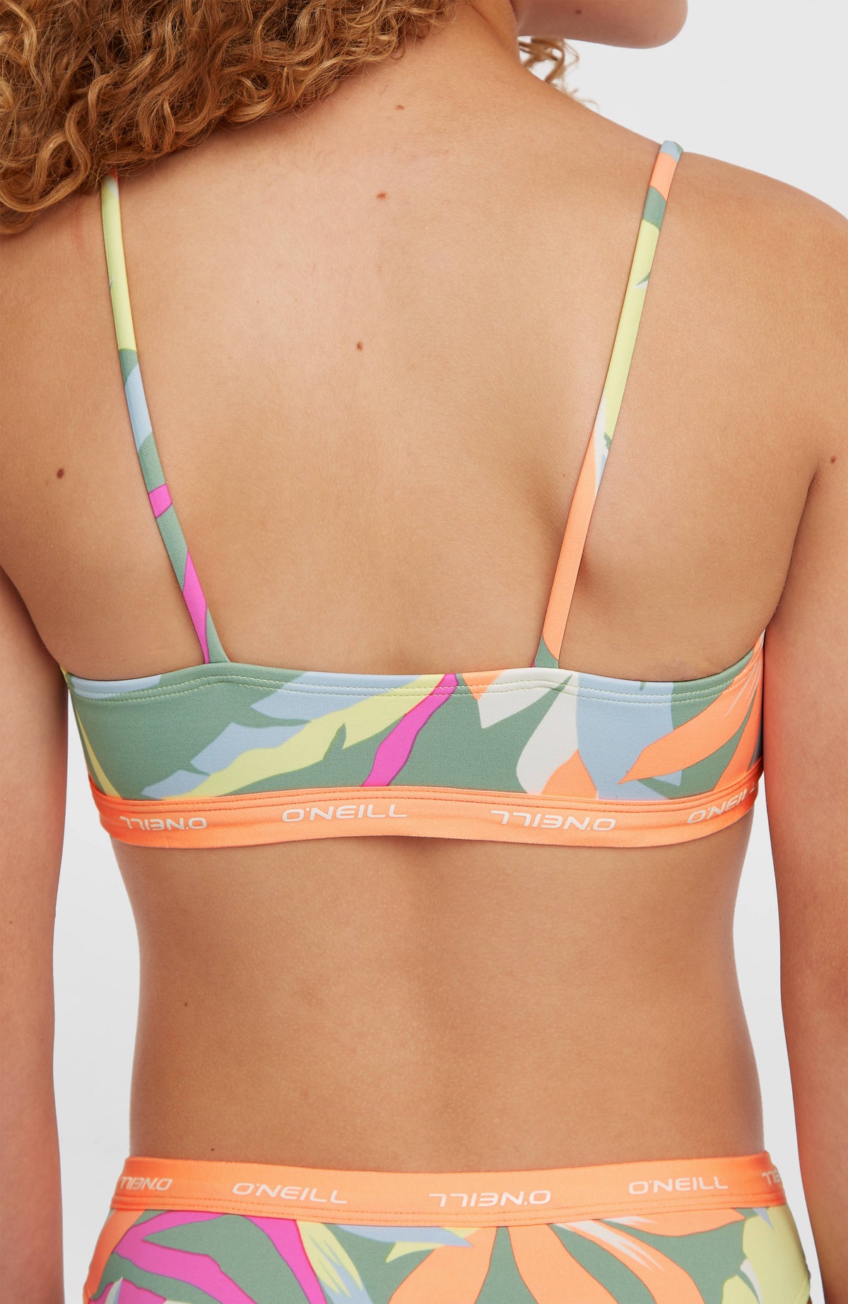 Sport Bikini-Set für Mädchen, grün mit Tropenmuster in Pink und Orange, Rückansicht des Bikinioberteils am Model