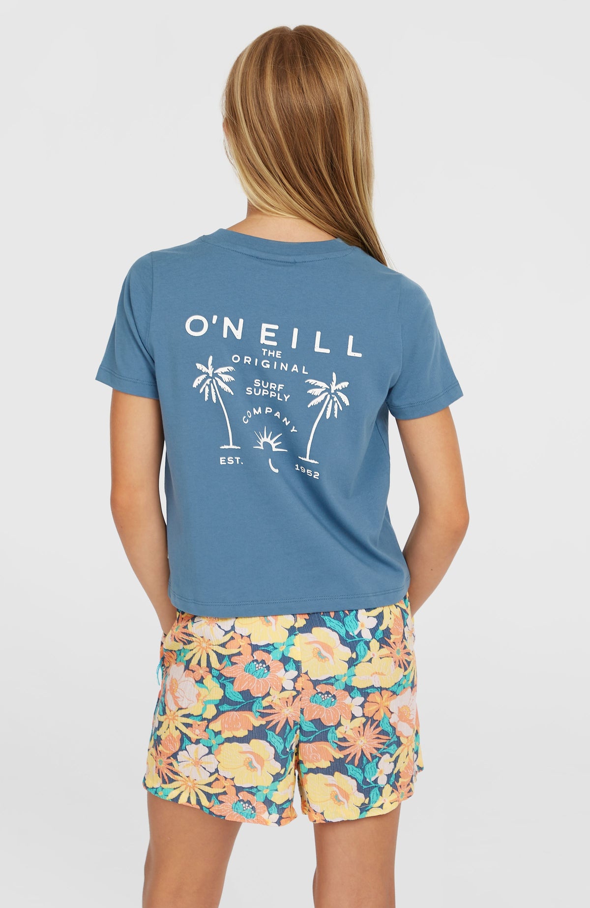 Short Graphic T-Shirt für Mädchen, blau mit Logo-Print in Weiß, vollständige Rückansicht am Model