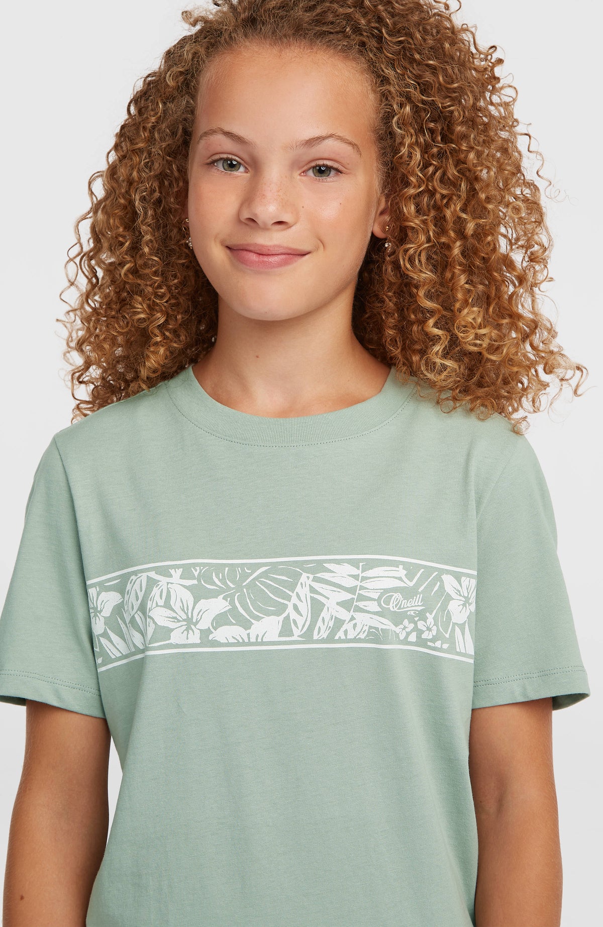 Graphic T-Shirt für Mädchen, grün mit Blumenmuster in Weiß, Nahaufnahme der Brustpartie am Model
