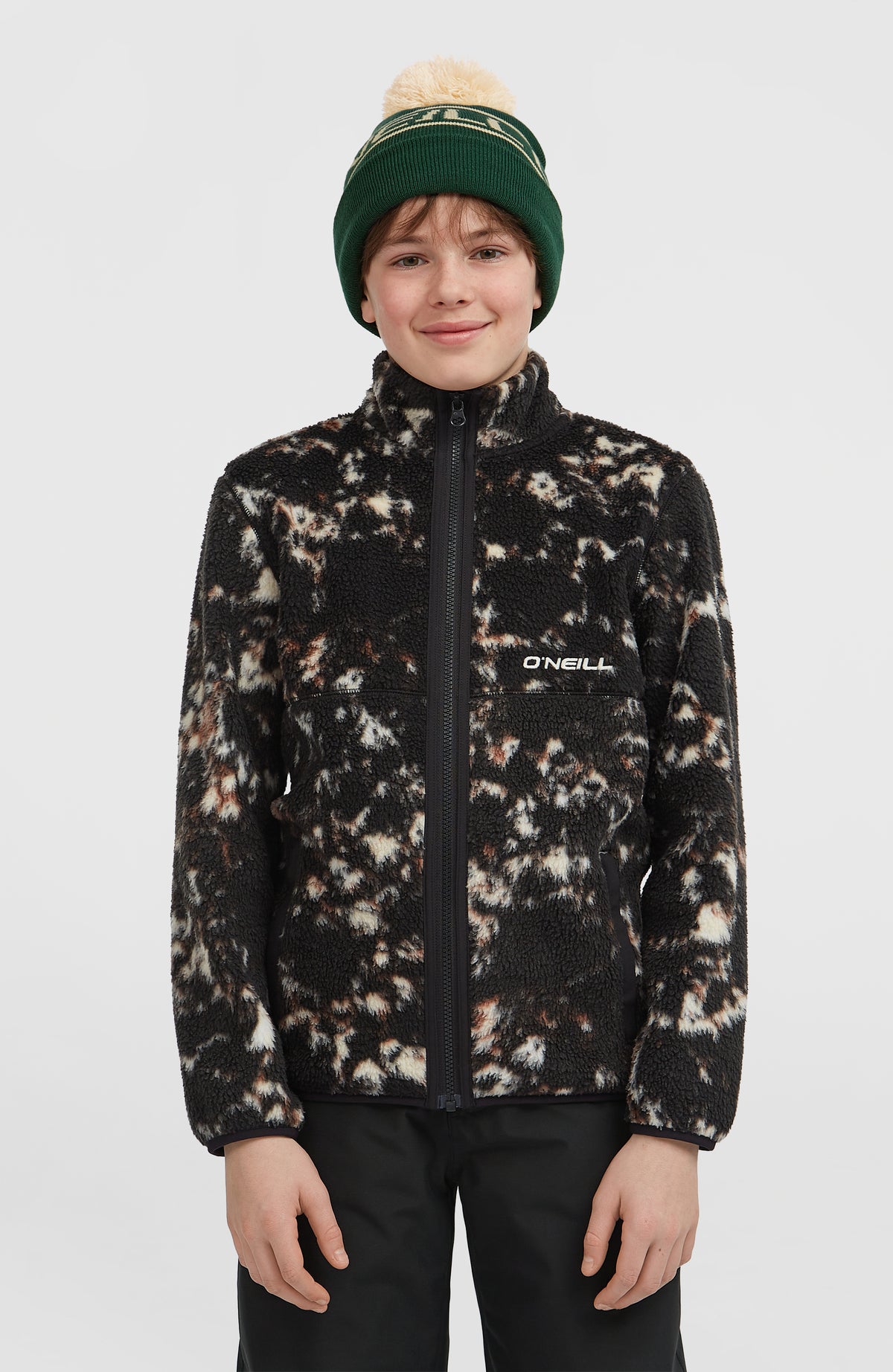 O'Neill Flauschige Fleecejacke mit Reißverschluss für Jungen, schwarz mit Allover-Muster in Beige, Vorderansicht am Model