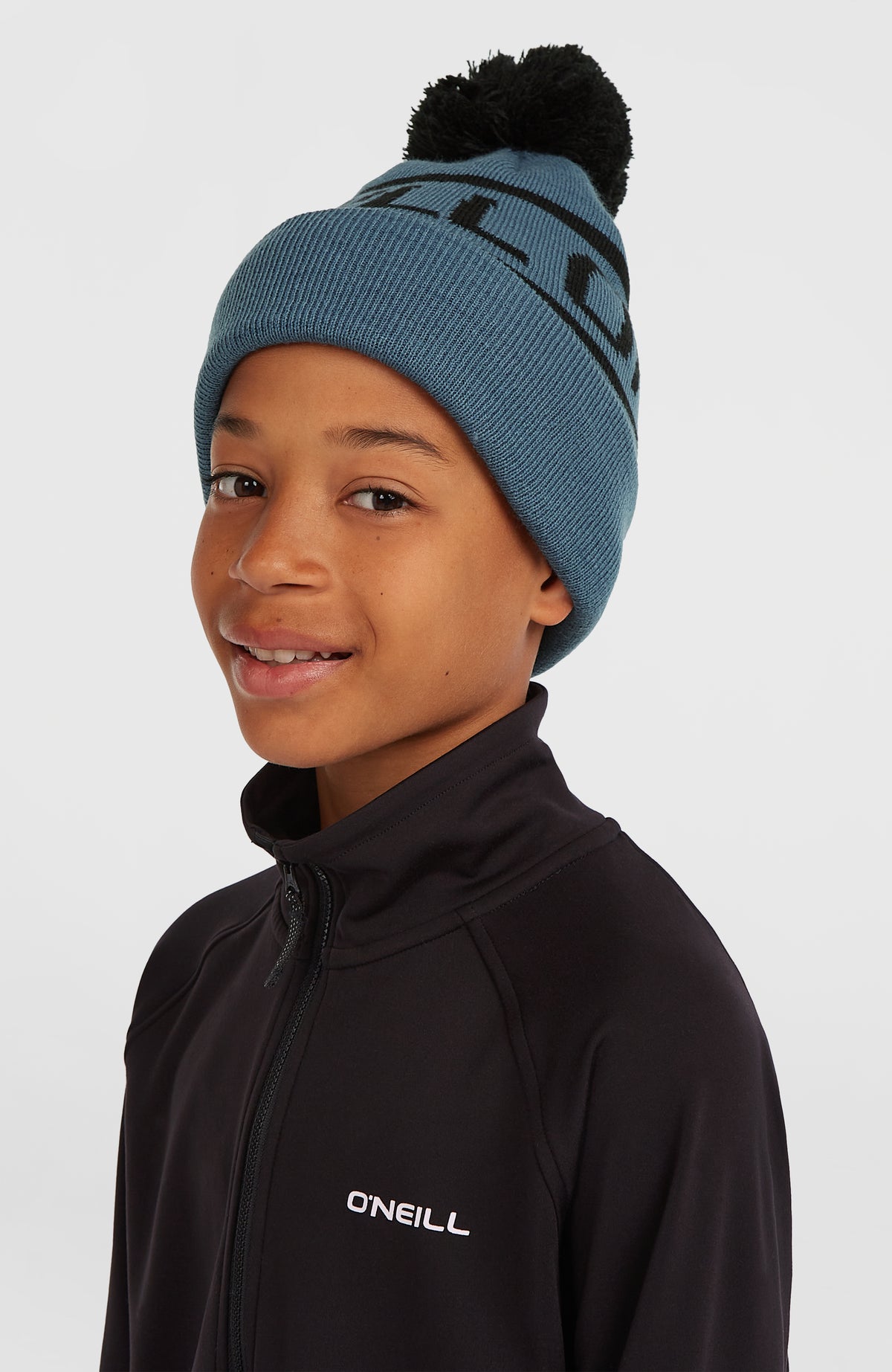 Powder Beanie für Jungen, blau mit Logo-Schriftzug in Schwarz, getragen am Model in frontaler Schrägansicht