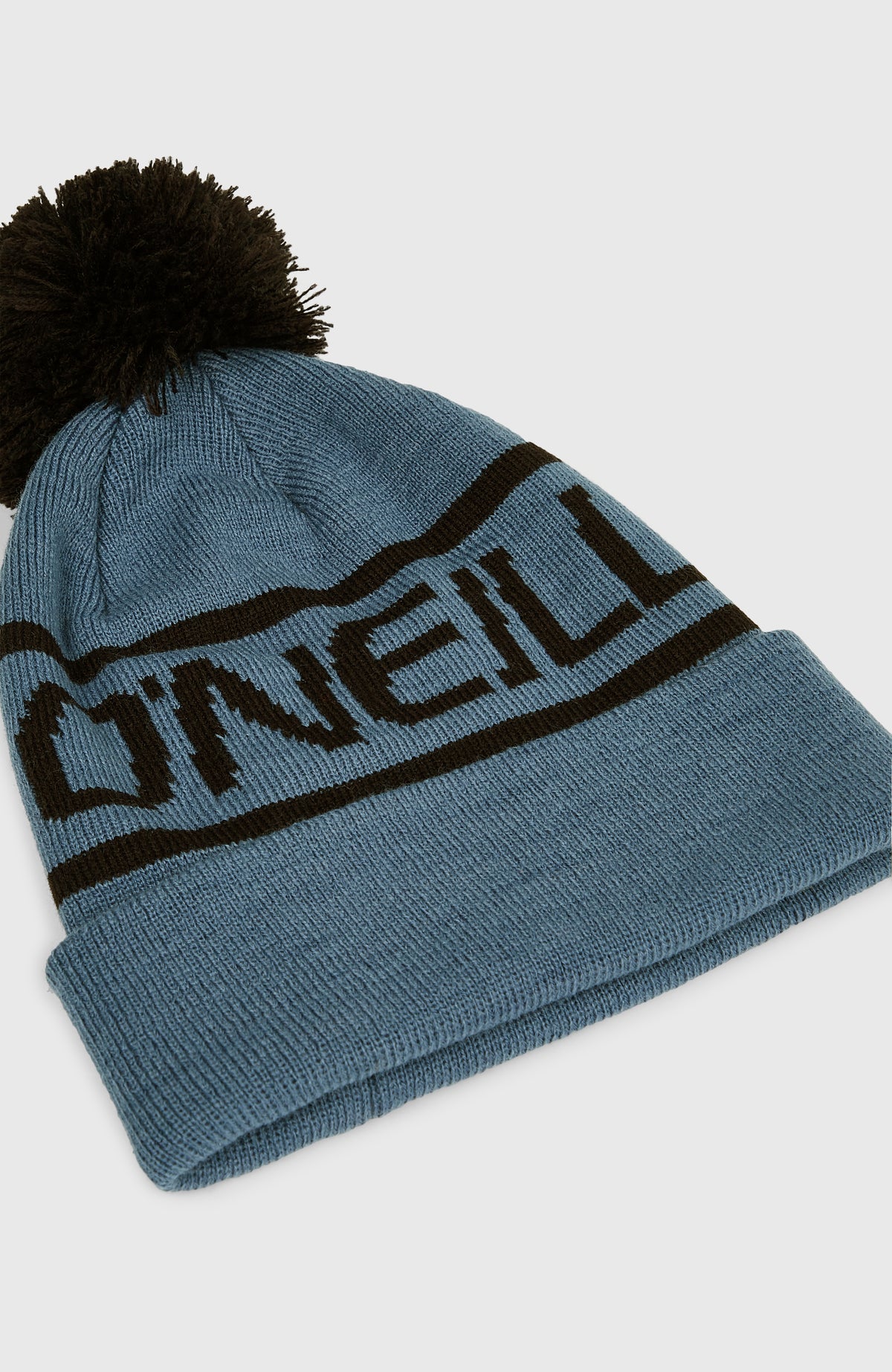 Powder Beanie für Jungen, blau mit Logo-Schriftzug in Schwarz, freigestellt von schräg oben mit Fokus auf den Umschlag