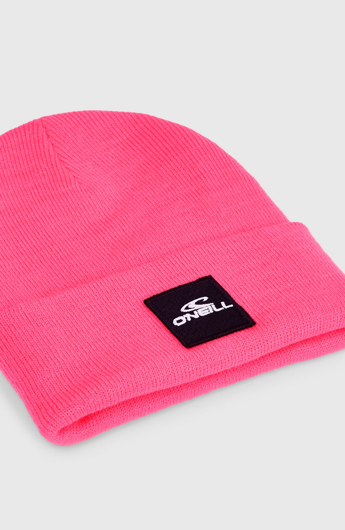 Pinke Snow Beanie für Kinder, freigestellt von schräg oben, Nahaufnahme des schwarzen Logo-Aufnähers
