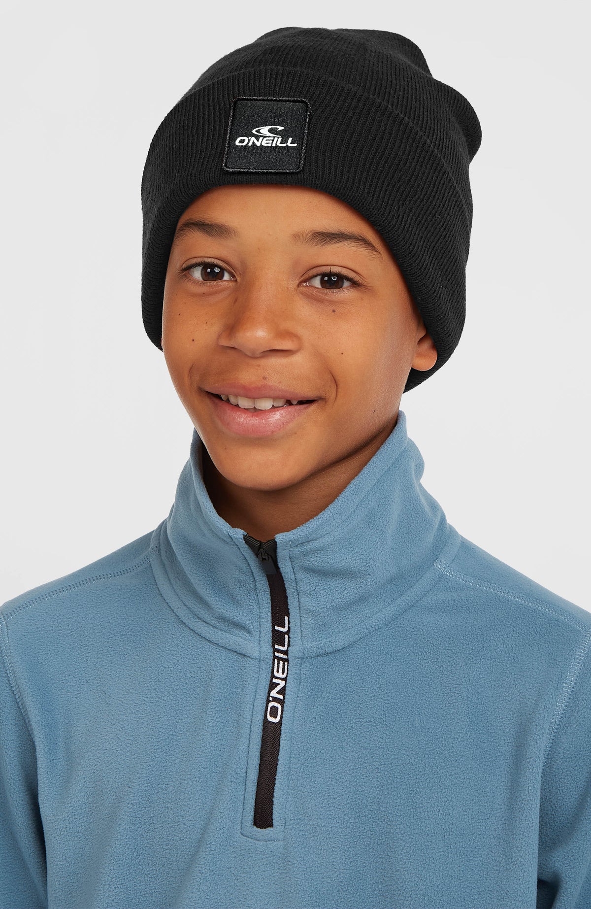 Snow Beanie für Jungen, schwarz, getragen am Model in Frontalansicht mit Logo-Patch auf dem Saum