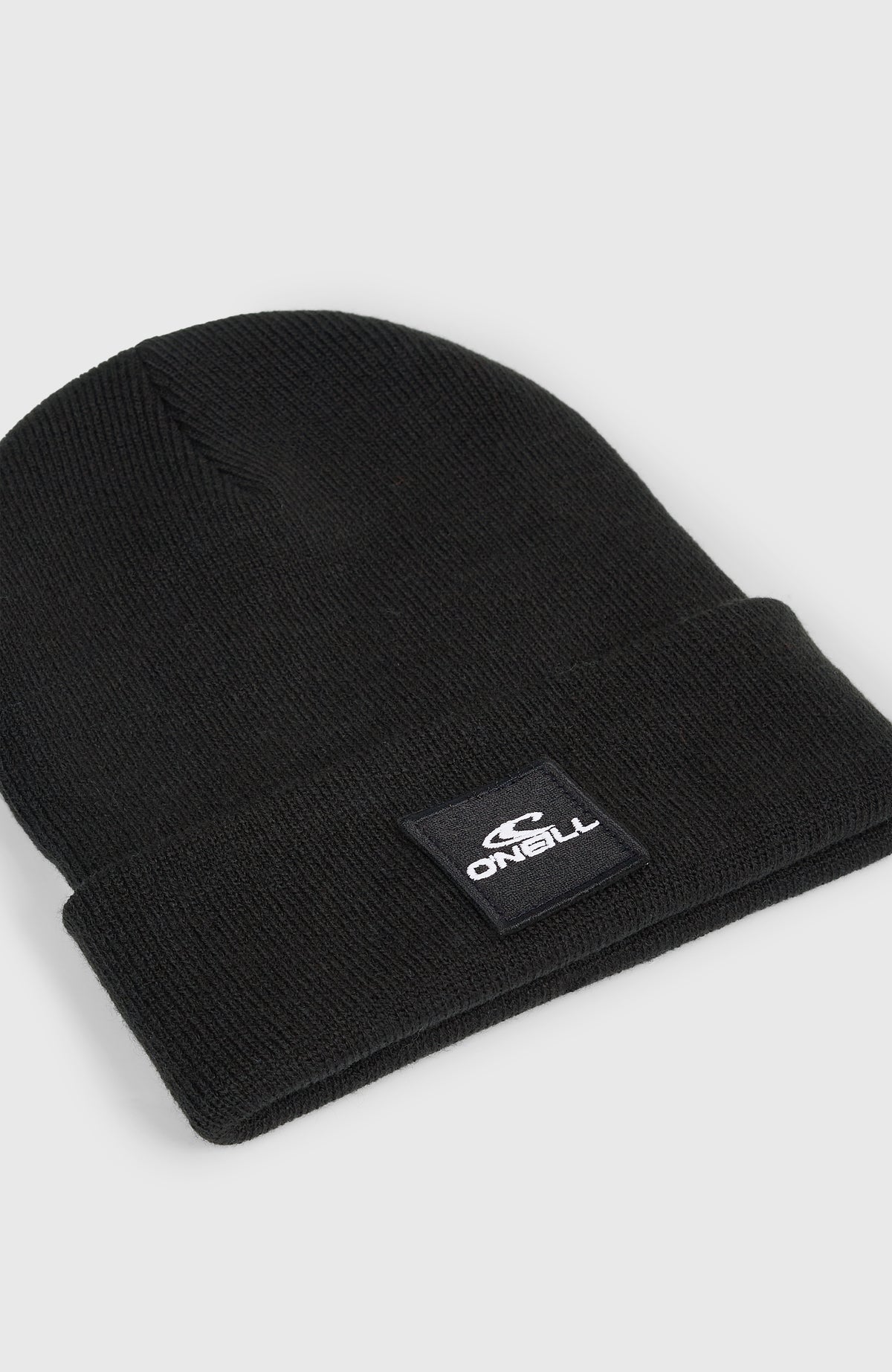 Snow Beanie für Jungen, schwarz, freigestellt von schräg oben mit Fokus auf den Logo-Patch am Saum