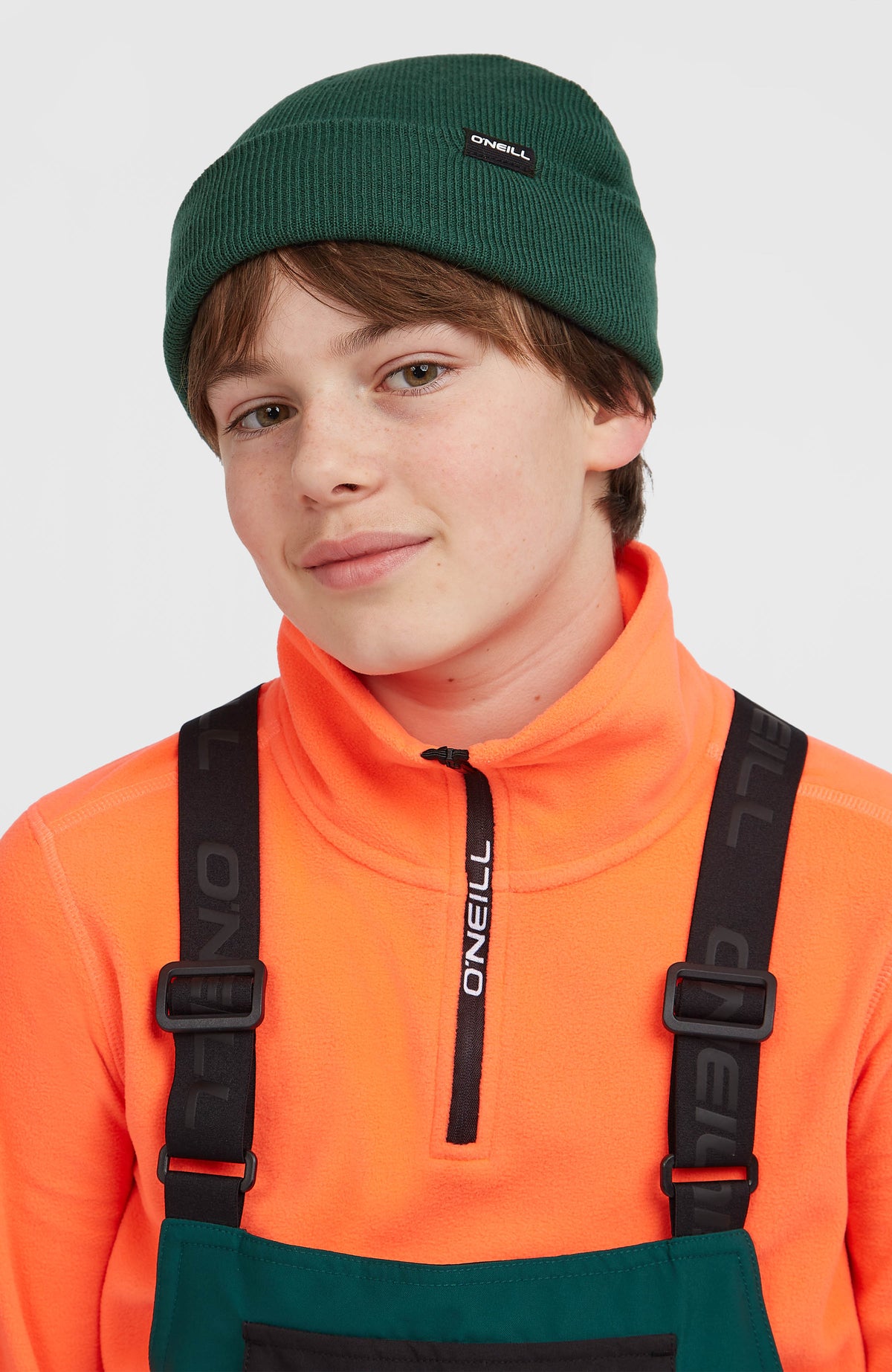 Grüne Dolomite Beanie für Jungen, getragen am Model mit umgeschlagenem Saum und Logo-Etikett
