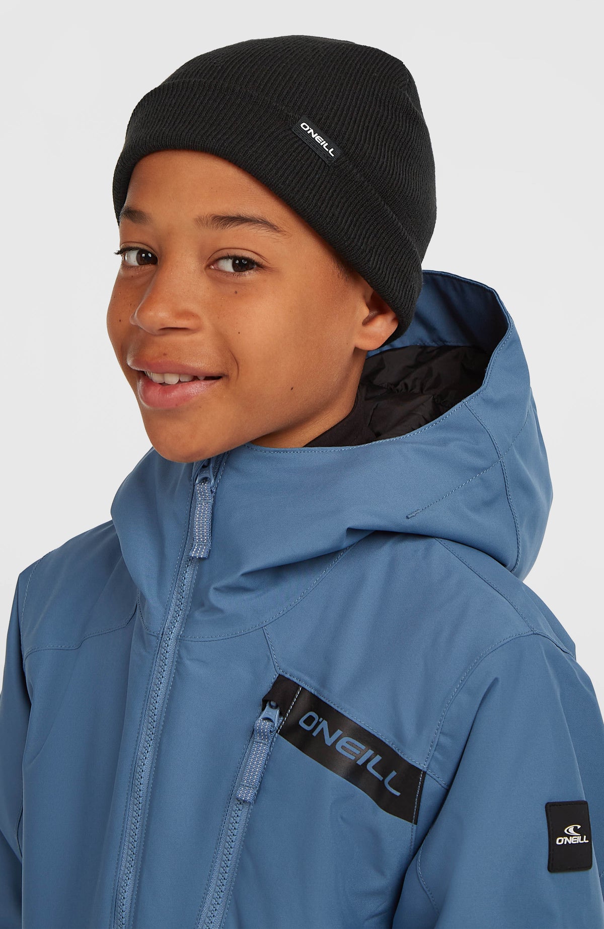 Dolomite Beanie für Jungen, schwarz, getragen am Model mit Winterjacke, seitliche Ansicht