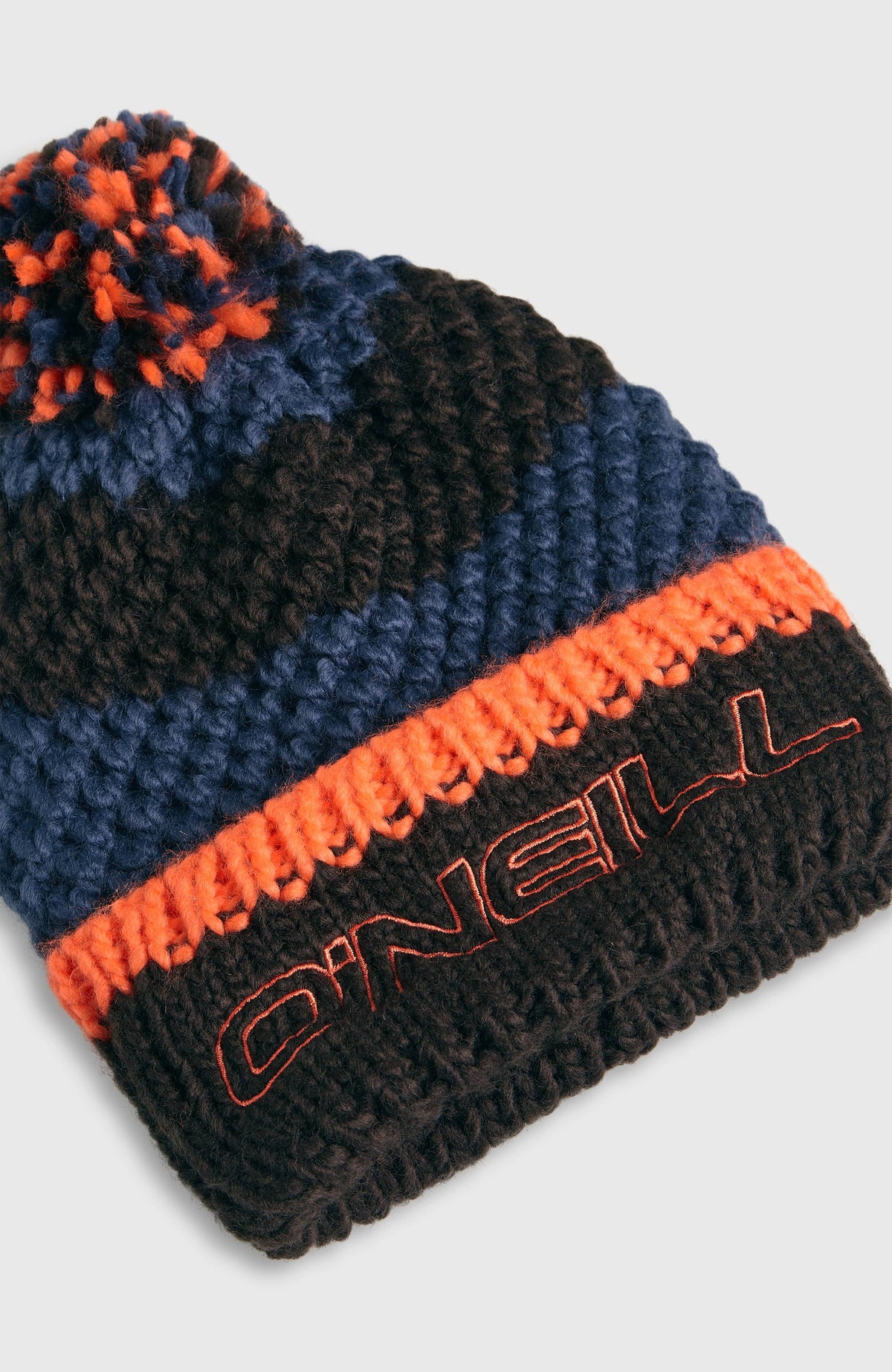 Nahaufnahme der blauen Powder Beanie mit Streifenmuster in Schwarz und Orange, Logo-Stickerei am Umschlag