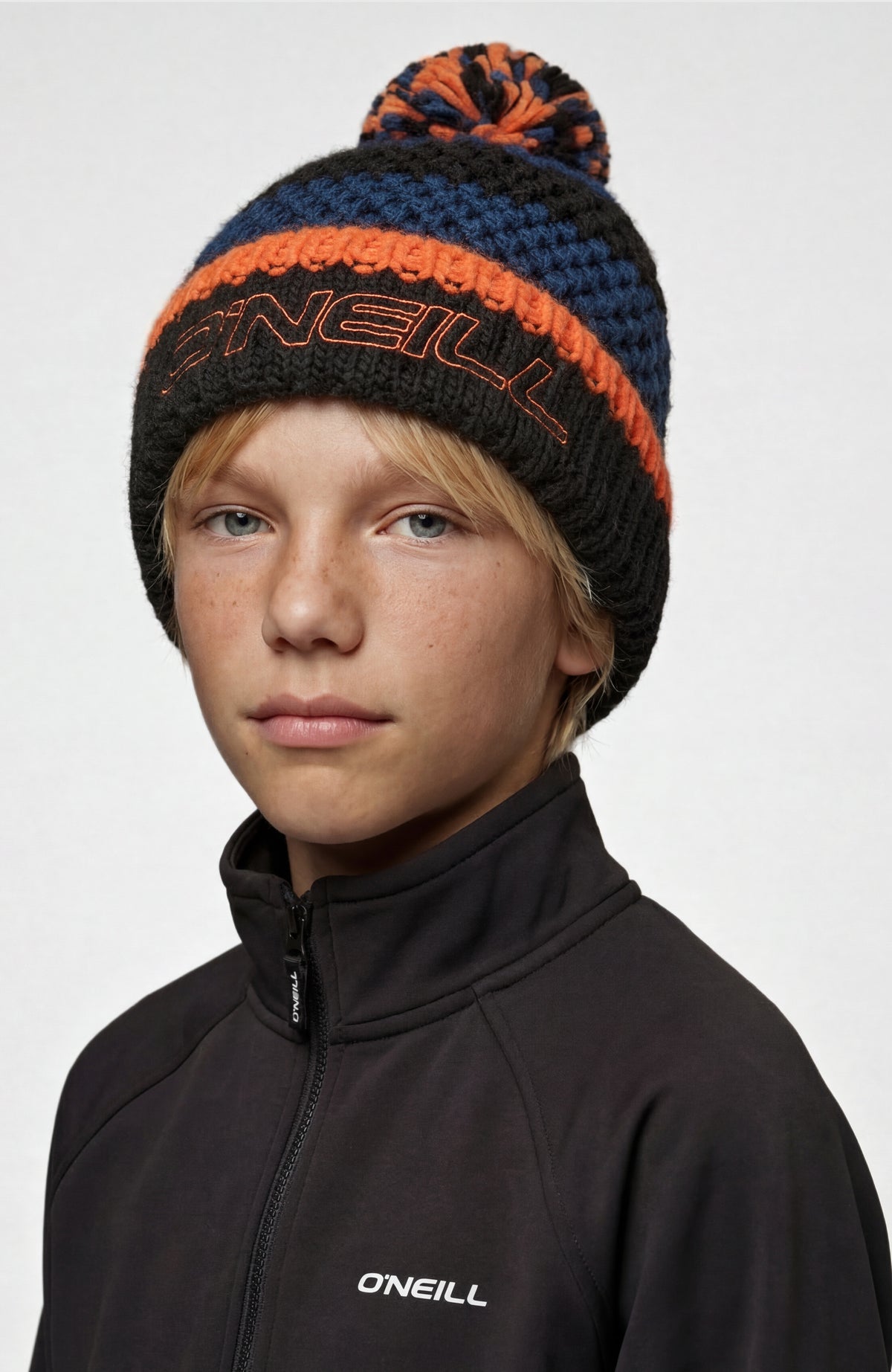 Powder Beanie für Jungen, blau mit Streifenmuster in Schwarz und Orange, Vorderansicht getragen am Model