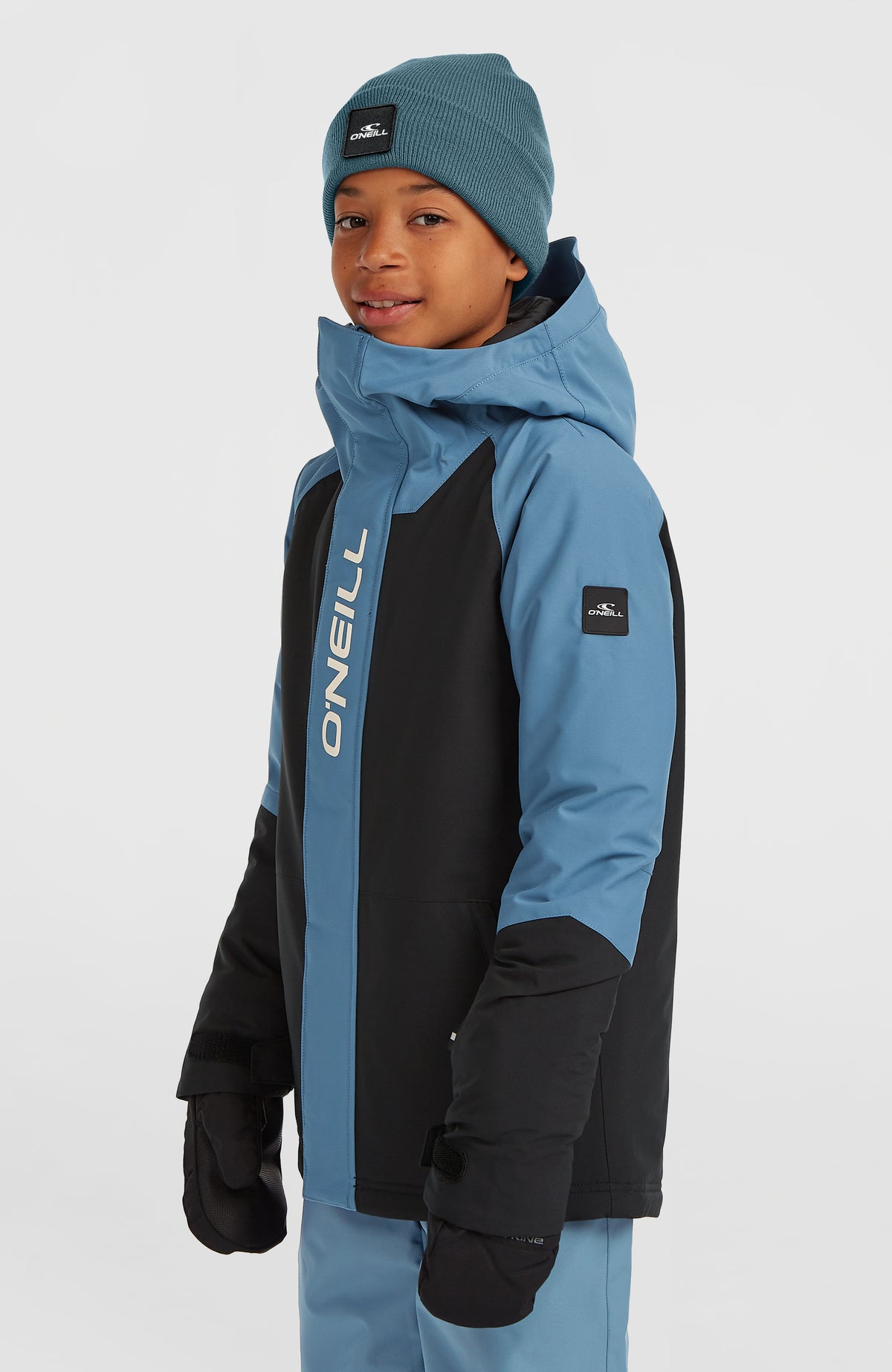 FWC'Play Ski- und Snowboardjacke für Jungen, blau, Halbprofilansicht am Model mit Logo-Badge am Ärmel