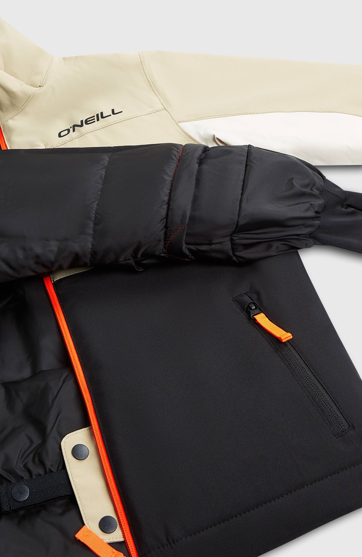 Nahaufnahme der beigen FWC'Cruz Triple Skijacke für Jungen, Detail von Schneefang, Innenfutter und Tasche