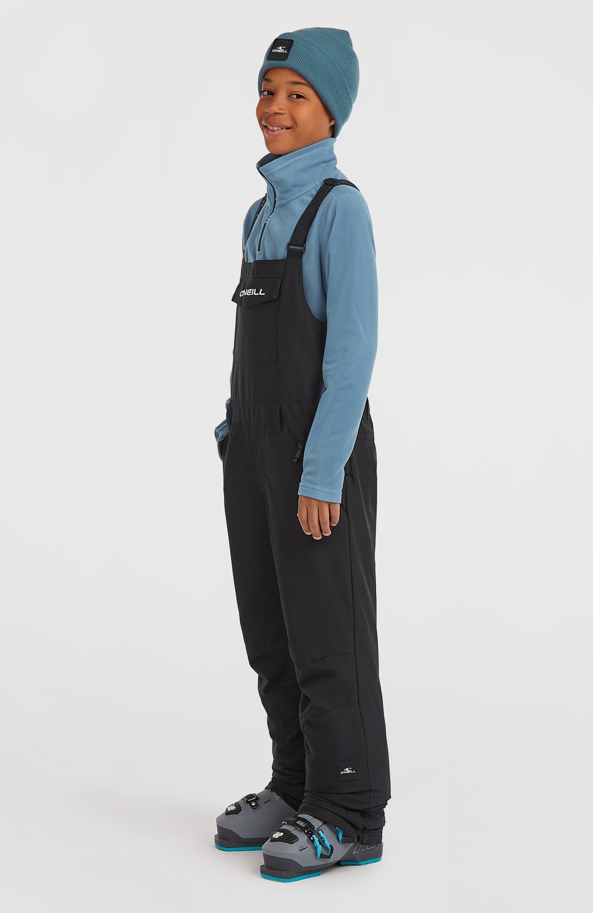 FWC'Cruz Bib Skihose für Kinder, schwarz, seitliche Ansicht getragen am Model mit geradem Beinverlauf
