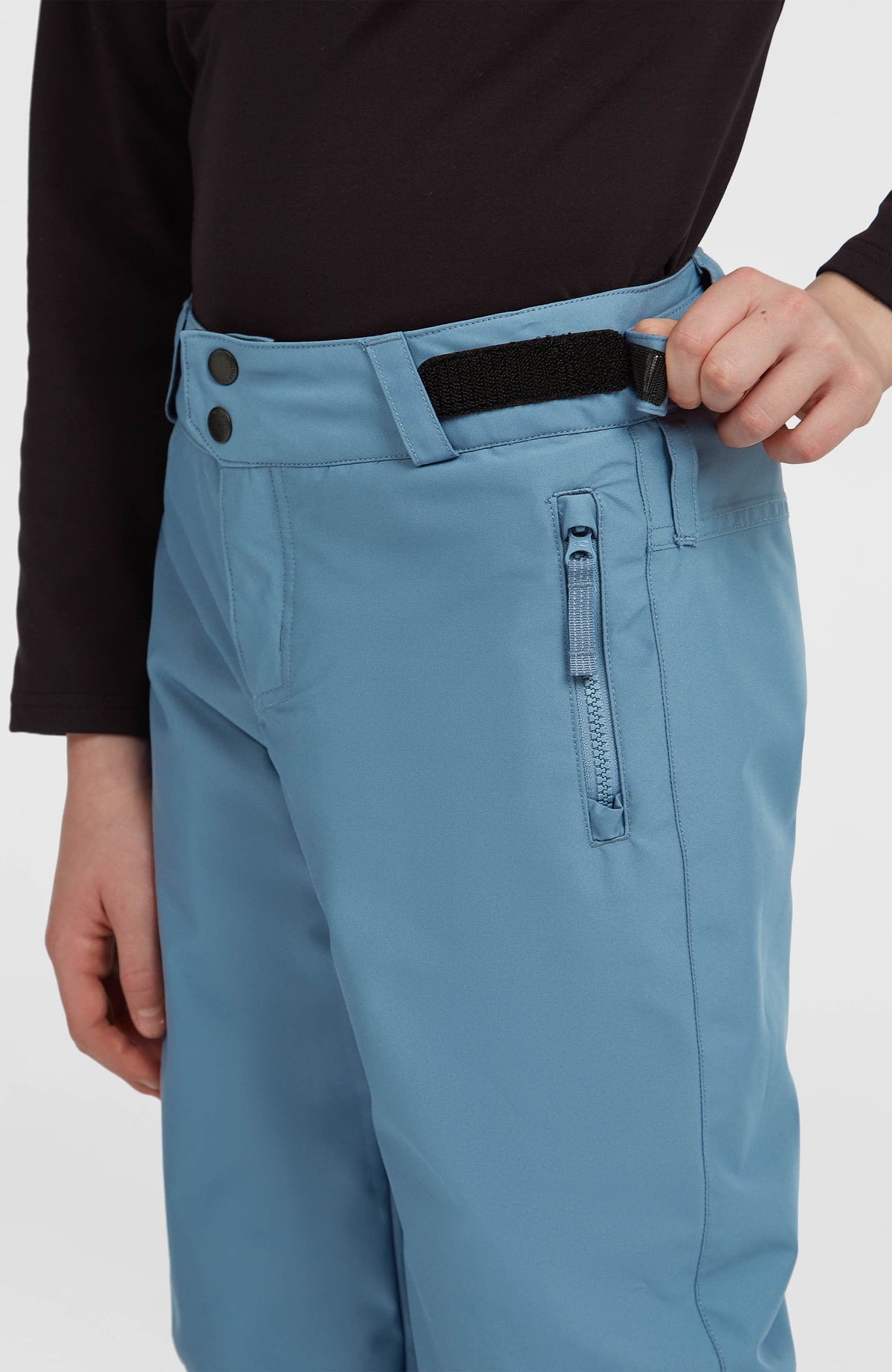 Nahaufnahme von Bund, Klettverschluss-Riegel und Reißverschlusstasche der blauen FWC'Cruz Skihose