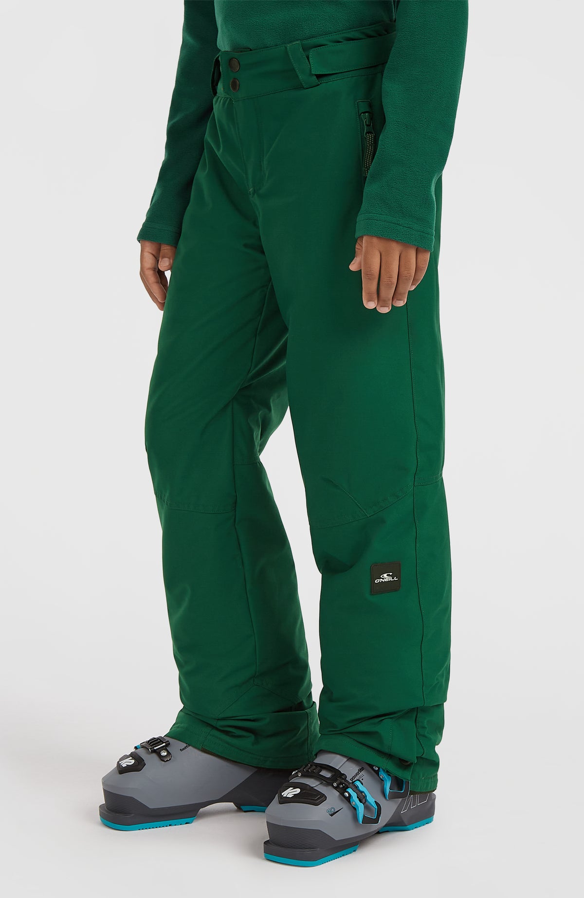 FWC'Cruz Skihose für Jungen, grün, Schrägansicht am Model mit Logo-Patch am unteren Hosenbein