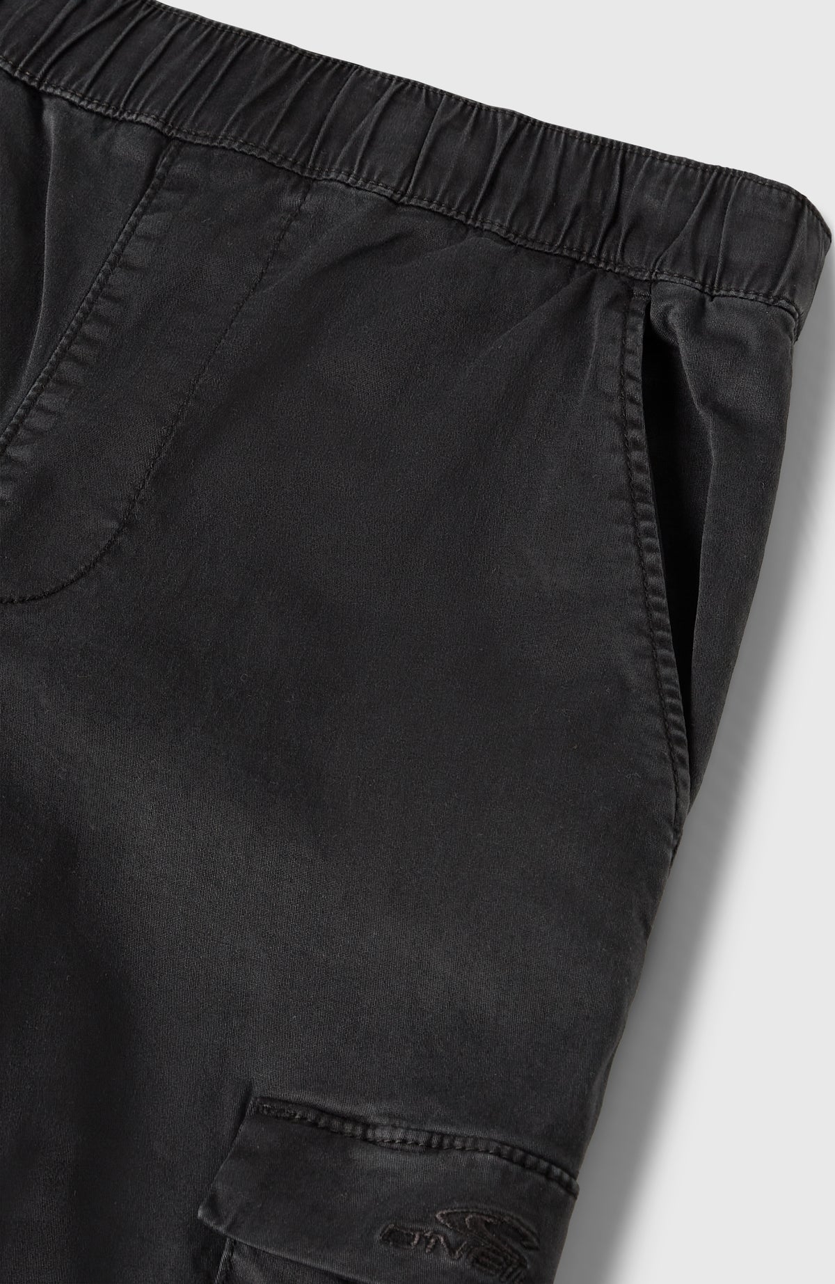 Nahaufnahme des elastischen Bundes und der Eingrifftasche der schwarzen Cargohose