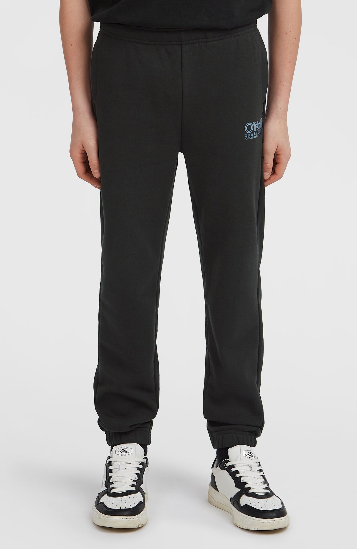 Essentials Jogginghose für Jungen, schwarz, Vorderansicht am Model mit geradem Schnitt und elastischem Saum