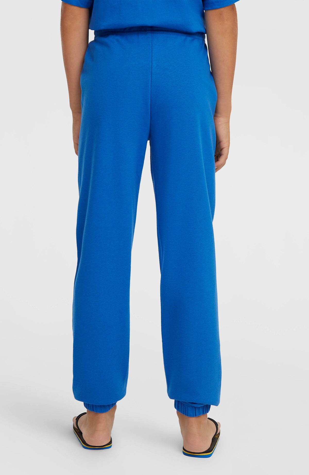 Blaue Cali Jogginghose für Jungen mit elastischen Beinabschlüssen, getragen am Model, Rückansicht