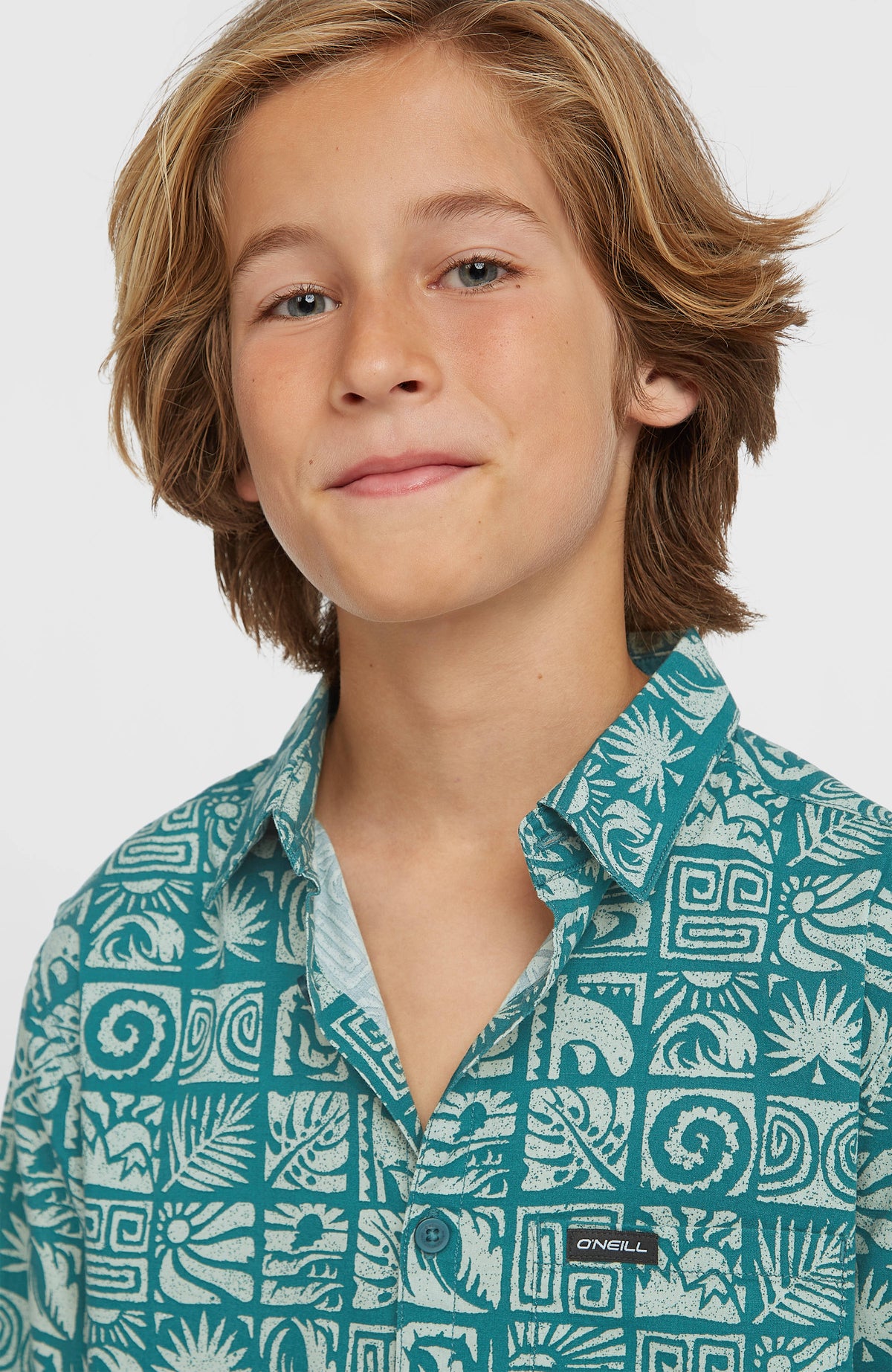 Print-Shirt für Jungen, blau mit Grafikmuster in Weiß, Nahaufnahme von Kragen und Brusttasche am Model