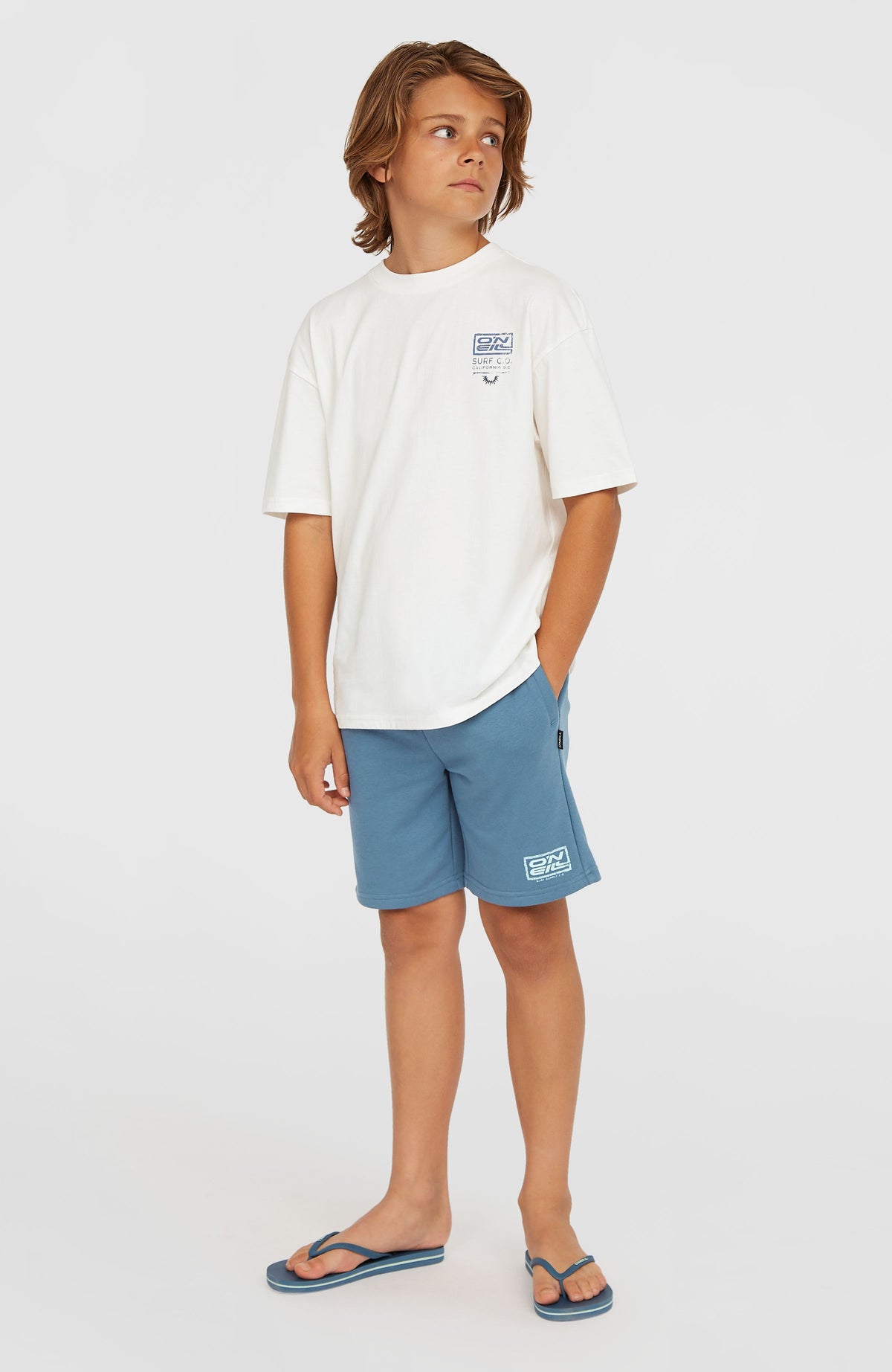 Logo Sweatshorts für Jungen, blau mit Logo-Print in Weiß, Schrägansicht getragen am Model