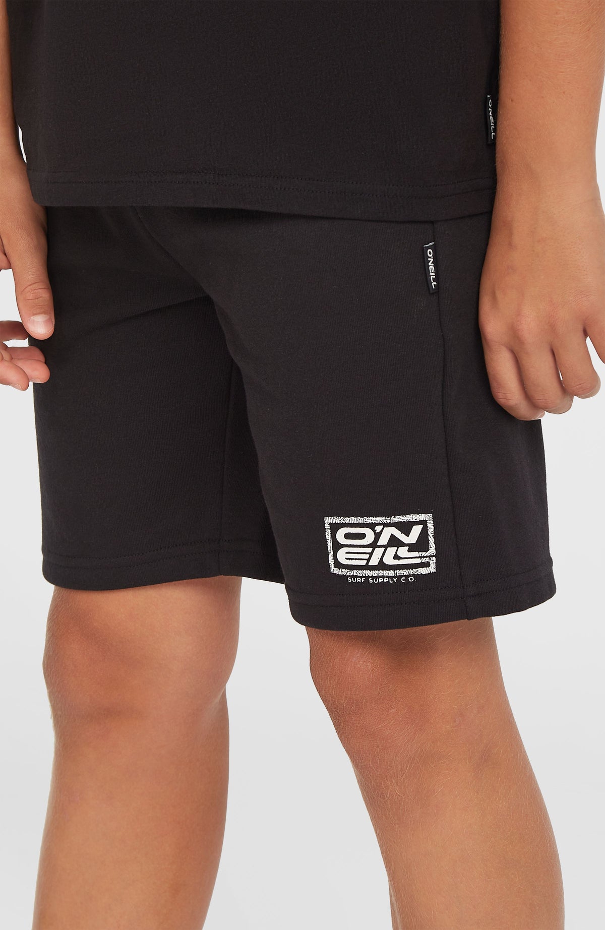 O'Neill Logo Sweatshorts für Jungen, schwarz, Nahaufnahme am Model mit Logo-Print am Beinabschluss