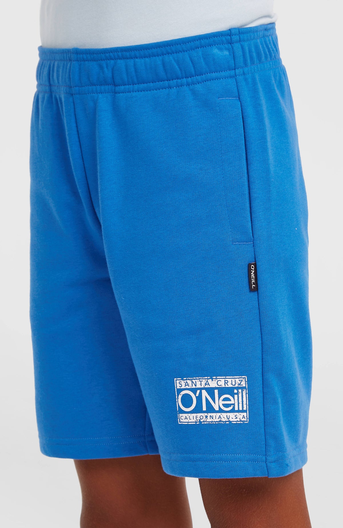 O'Neill Cali Sweatshorts für Jungen, blau mit Logo-Print in Weiß, Nahaufnahme am Model von Bund und Hosenbein
