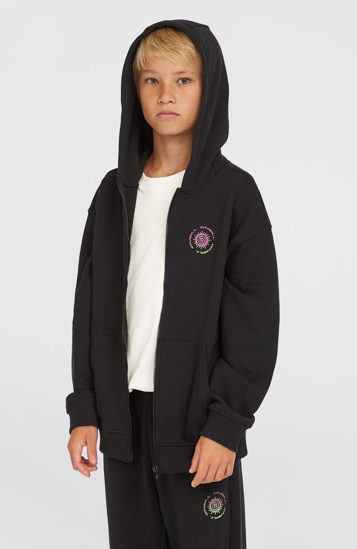 O'Neill Graphic Kapuzenjacke mit Reißverschluss für Jungen, schwarz mit Grafik-Print in Pink und Grün, am Model