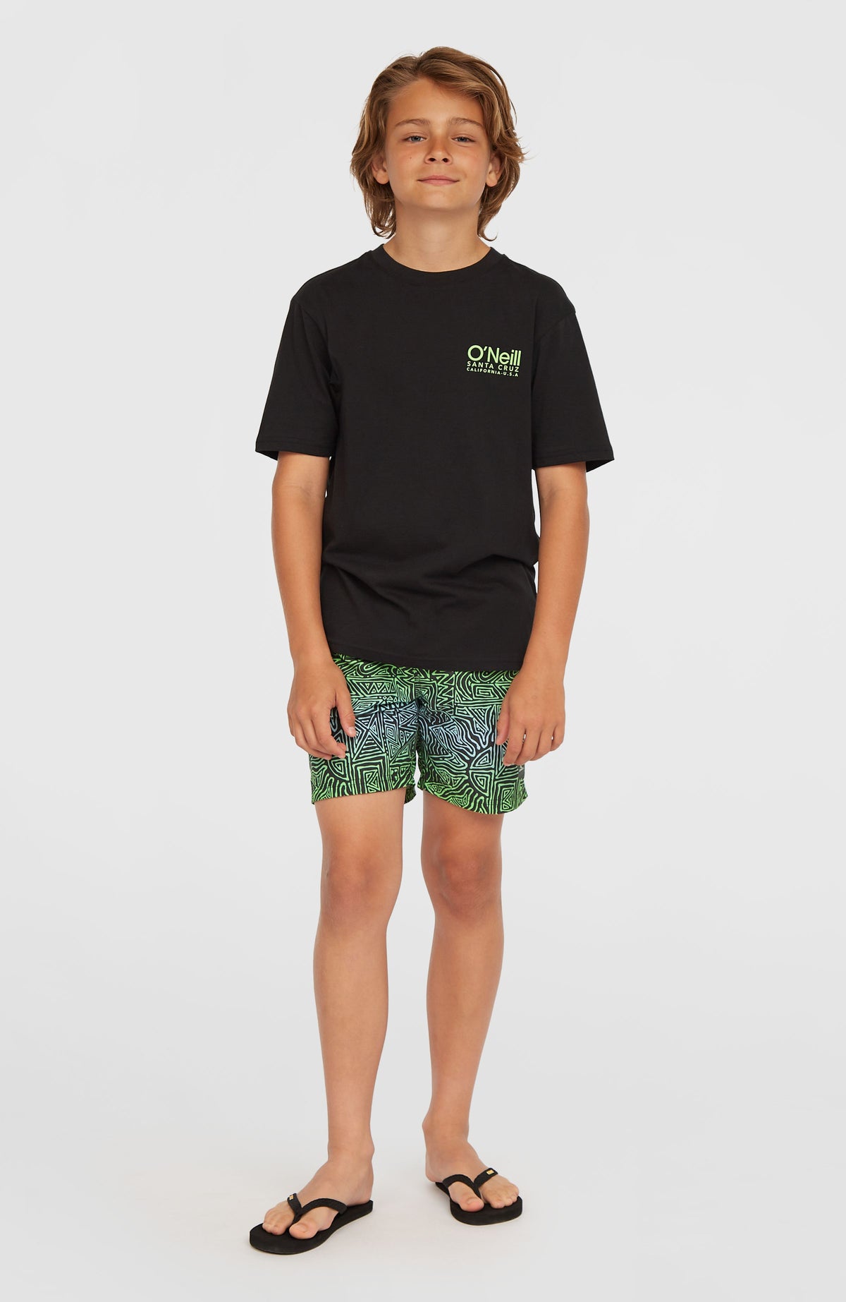 Blaue Cali 14'' Badehose für Jungen mit Grafikmuster in Grün, Ganzkörperansicht von vorne getragen am Model