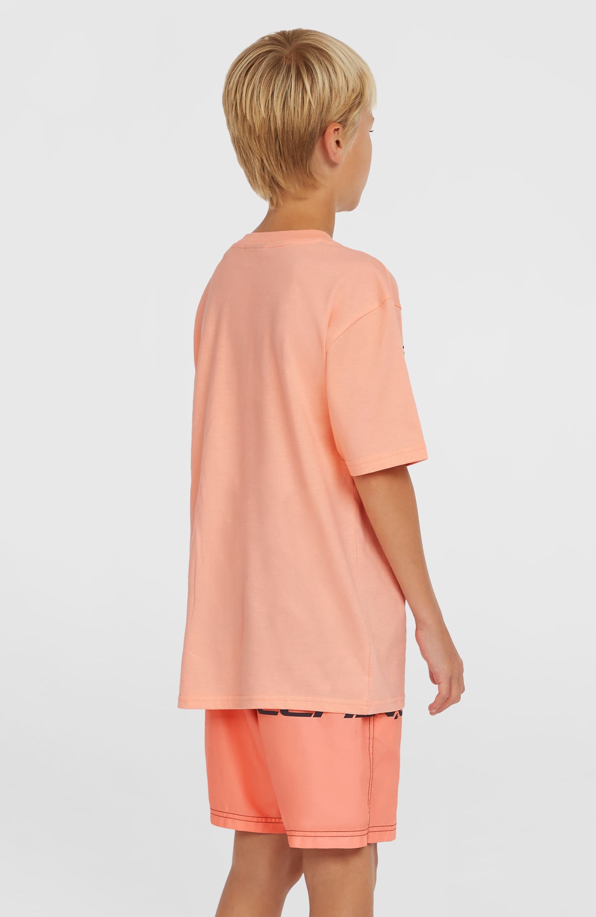 Cali Stripe 14'' Badehose für Jungen, pink mit Logo-Print in Schwarz, Dreiviertelansicht von hinten am Model